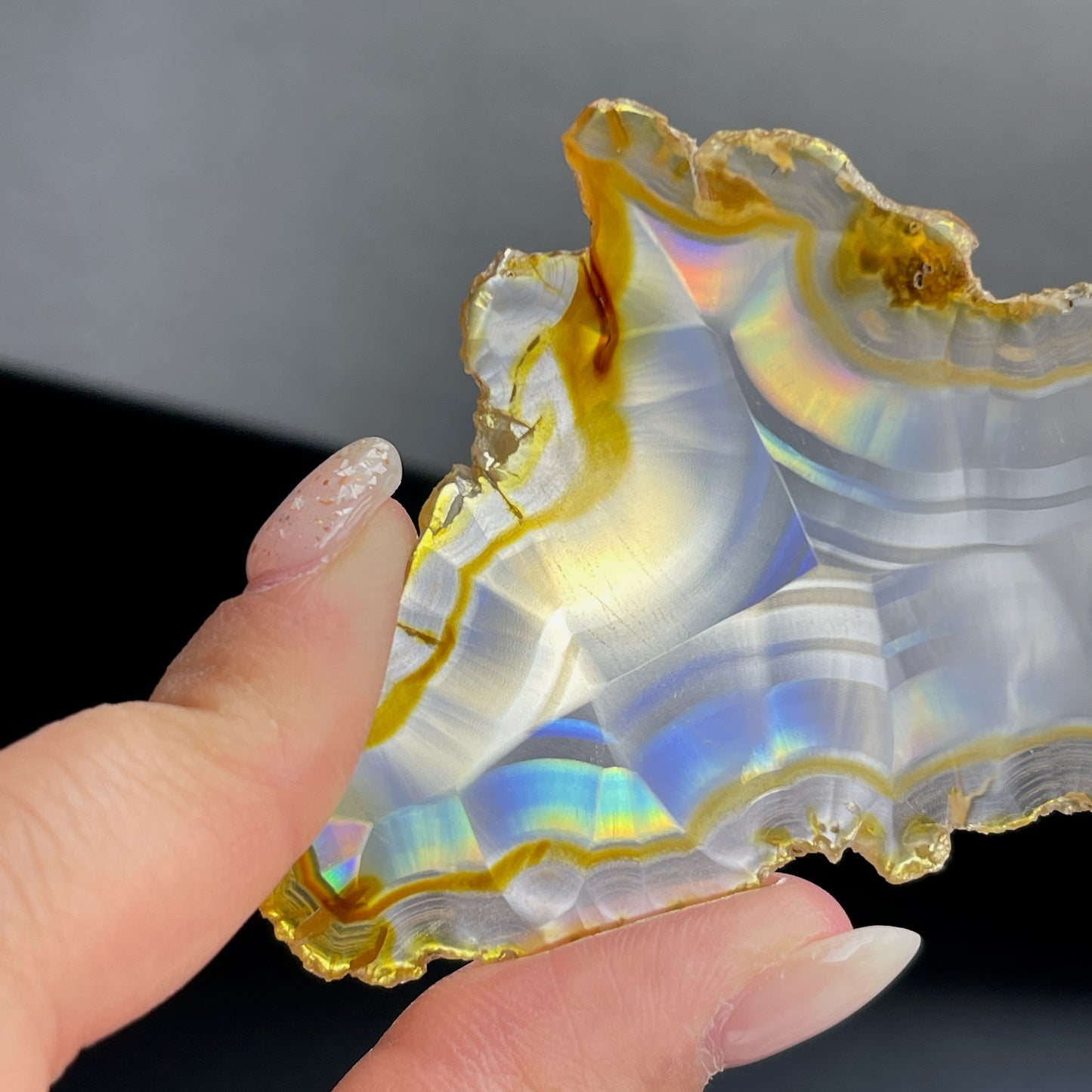 虹彩瑪瑙是一種細帶狀、半透明的石髓 (Chalcedony),並且可將透射光分解成為光譜顏色。”Iris”意為”彩虹”或”虹彩虹色的”,源自於希臘彩虹女神的名字。 Iris agate is a finely-banded, translucent variety of chalcedony that breaks up transmitted light into spectral colors. The word “Iris” means “rainbow” or “to make iridescent” and is derived from the name of the Greek goddess of the rainbow. *以上資料轉載自 “GIA Hong Kong - Jul 2021”