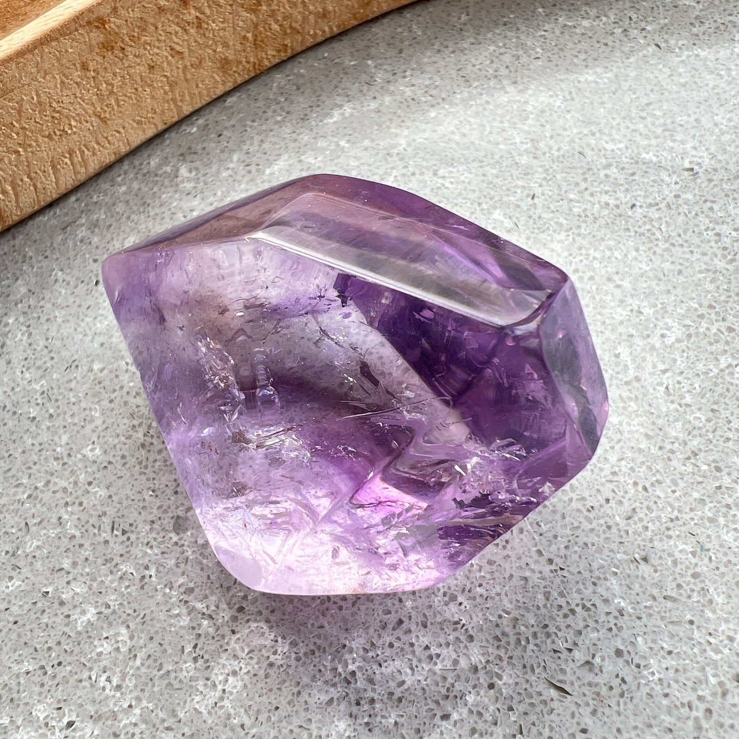 彩虹紫水晶隨形

【 棲於光影間的彩虹 】｜ 紫水晶隨形

這不只是一顆礦石，更像是大自然隨手裁下的一片靜謐光影。

紫水晶深邃且溫柔的色澤，在不規則的隨形切割下，展現出最原始、不經修飾的生命力。當自然光線穿透晶體，內部的天然冰裂縫隙彷彿成了光的稜鏡，在特定角度下綻放出璀璨的彩虹光芒，那是藏在時間深處的驚喜。