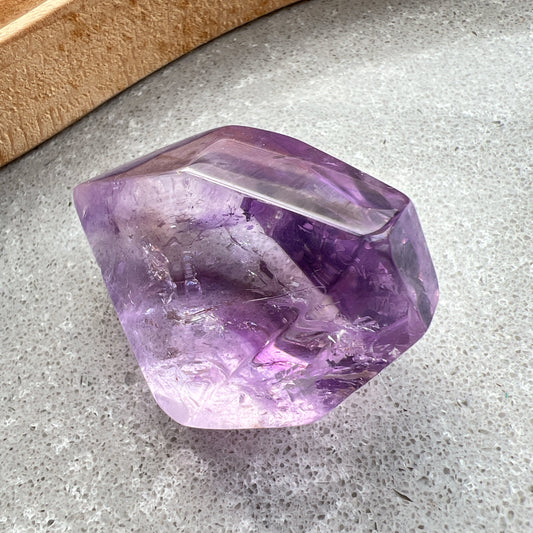 彩虹紫水晶隨形

【 棲於光影間的彩虹 】｜ 紫水晶隨形

這不只是一顆礦石，更像是大自然隨手裁下的一片靜謐光影。

紫水晶深邃且溫柔的色澤，在不規則的隨形切割下，展現出最原始、不經修飾的生命力。當自然光線穿透晶體，內部的天然冰裂縫隙彷彿成了光的稜鏡，在特定角度下綻放出璀璨的彩虹光芒，那是藏在時間深處的驚喜。