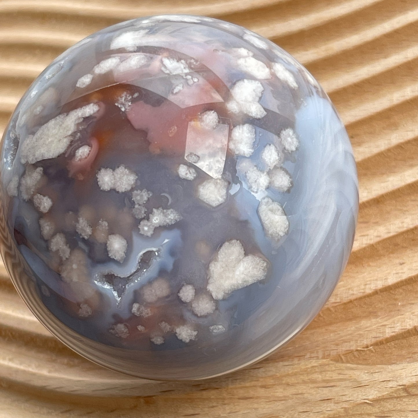 櫻花瑪瑙球  灰藍瑪瑙，nice banding agate , 又有可愛druzy 靚靚晶洞✨  瑪瑙-Agate品種繁多，整個瑪瑙家族十分龐大。其中一種瑪瑙充滿溫柔優雅之美，深受女仕們喜愛，就是櫻花瑪瑙 - Blossoms Agate🌸 櫻花瑪瑙被視為寶石中的「第三眼」，靈性十足，象徵友善與愛心，也代表希望。 櫻花瑪瑙晶體內含粉白色、猶如朵朵盛開之櫻花的共生礦，每枝形態獨一無二，為人帶來溫柔細膩的內涵，會令人要停下來慢慢欣賞佢嘅美。  -能令人精神放鬆，捉升睡眠質素 -瑪瑙具有平衡，穩定及保護的作用 -也是護身符及辟邪物，有保平安功效 -瑪瑙維持身心和諧，增強愛、忠誠及勇氣