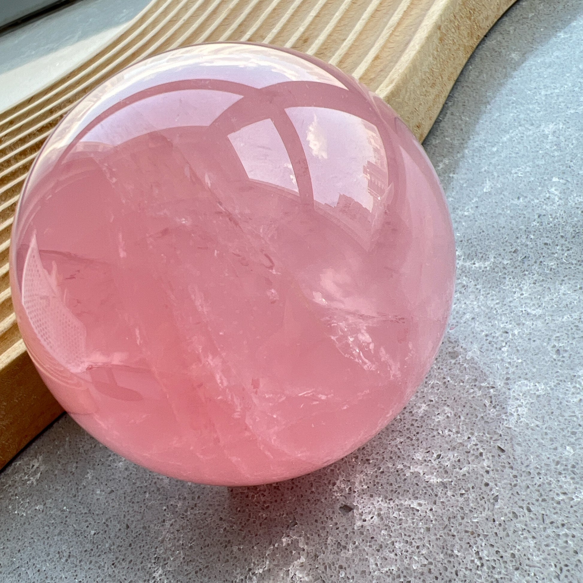 星光粉水晶球
凝視那一抹柔粉：讓生活回歸溫柔的本質

家中最迷人的風景，往往來自於自然。這顆粉水晶球不只是裝飾，它是大自然耗費千載凝結出的溫柔色澤。在自然光線的折射下，淡淡的粉色調在球體內交織出如雲霧般的天然冰裂紋與棉旭，每一面都擁有獨一無二的紋理與表情。

比起繁複的裝修，我們更相信「質地」帶來的力量。將它置於床頭、書桌或客廳的一隅，粉水晶柔和的色調能瞬間柔化空間的線條。在繁忙的日常步調中，它像是一個安靜的陪伴者，提醒我們放慢呼吸，感受當下的寧靜。
