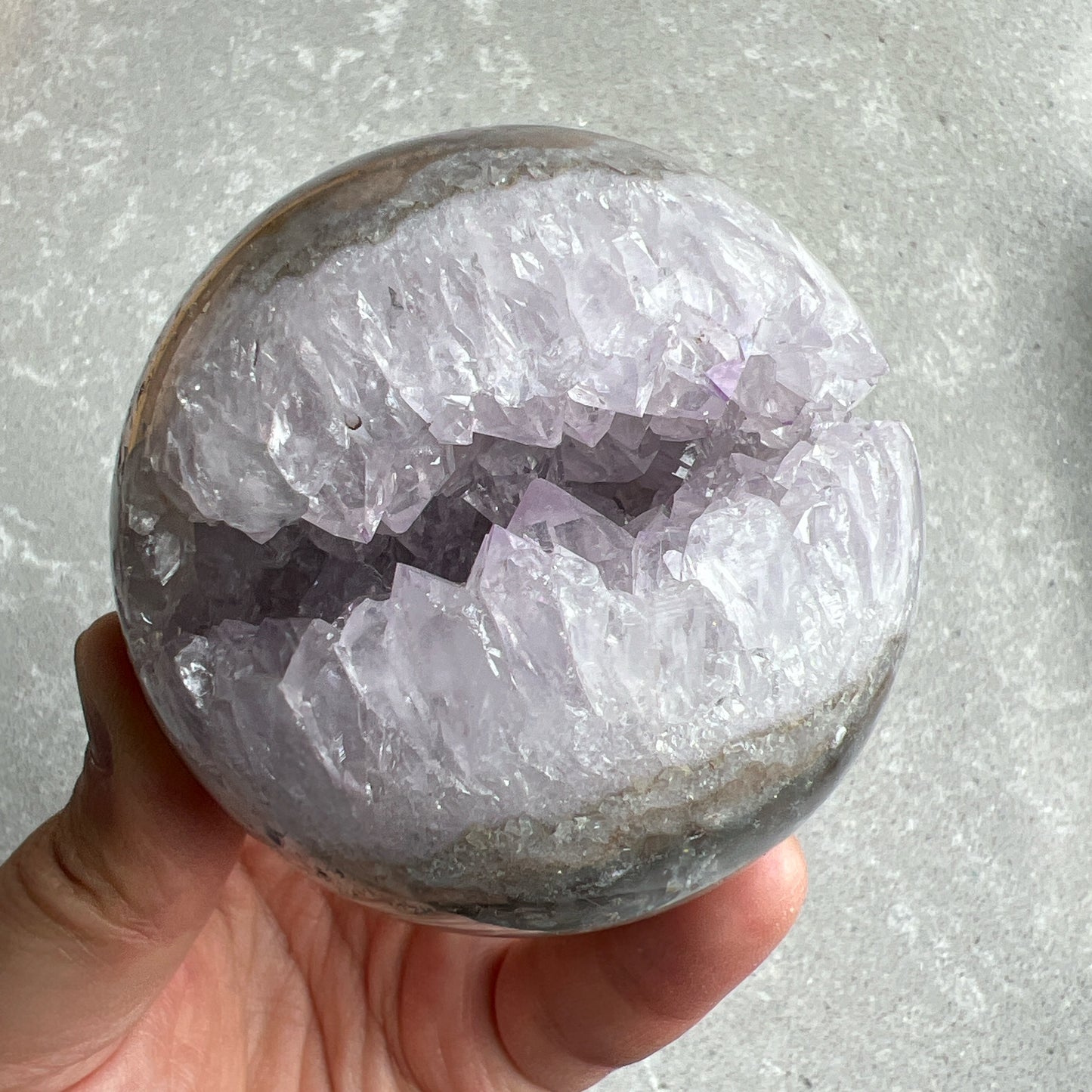 巴西紫晶開口笑球

這是一個全晶體，冇任何石皮，淡淡嘅丁香紫色，閃閃嘅晶牙，

水晶球背後還共生少量方解石。

開口笑水晶簇球是一種很多人喜愛的風水石，有招財聚財，招貴人之效用，如果想放置的位置唔容許擺設大型晶洞，這種開口笑一定會是最佳選擇😊

紫晶，一向代表著智慧，加強決策力，利人緣，對舒緩緊張情緒有幫助，促進問題解決。