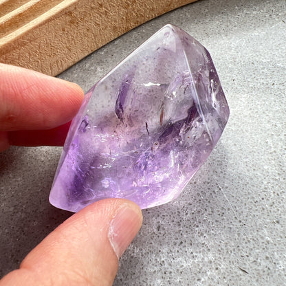 彩虹紫水晶隨形

【 棲於光影間的彩虹 】｜ 紫水晶隨形

這不只是一顆礦石，更像是大自然隨手裁下的一片靜謐光影。

紫水晶深邃且溫柔的色澤，在不規則的隨形切割下，展現出最原始、不經修飾的生命力。當自然光線穿透晶體，內部的天然冰裂縫隙彷彿成了光的稜鏡，在特定角度下綻放出璀璨的彩虹光芒，那是藏在時間深處的驚喜。