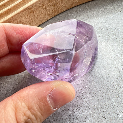 彩虹紫水晶隨形

【 棲於光影間的彩虹 】｜ 紫水晶隨形

這不只是一顆礦石，更像是大自然隨手裁下的一片靜謐光影。

紫水晶深邃且溫柔的色澤，在不規則的隨形切割下，展現出最原始、不經修飾的生命力。當自然光線穿透晶體，內部的天然冰裂縫隙彷彿成了光的稜鏡，在特定角度下綻放出璀璨的彩虹光芒，那是藏在時間深處的驚喜。
