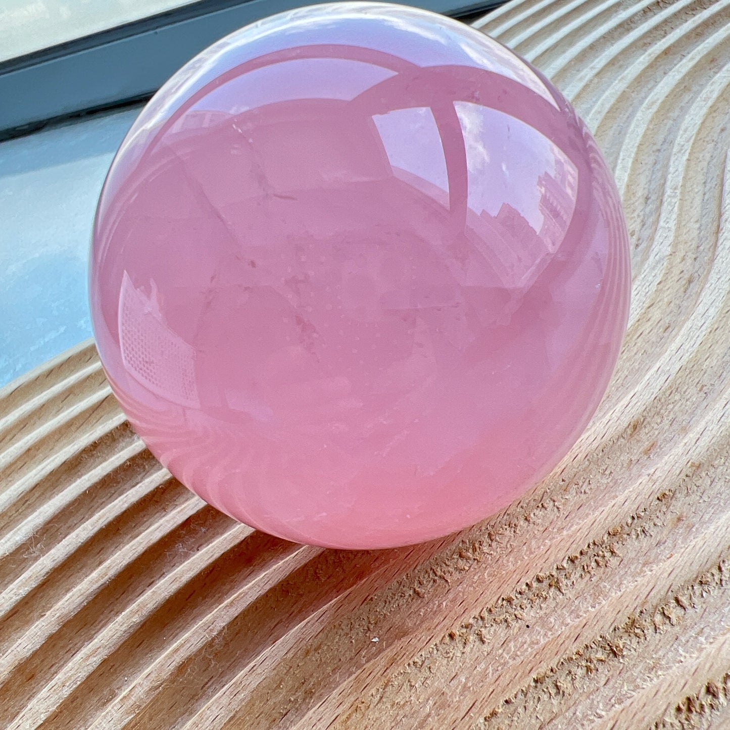 星光粉水晶球
凝視那一抹柔粉：讓生活回歸溫柔的本質

家中最迷人的風景，往往來自於自然。這顆粉水晶球不只是裝飾，它是大自然耗費千載凝結出的溫柔色澤。在自然光線的折射下，淡淡的粉色調在球體內交織出如雲霧般的天然冰裂紋與棉旭，每一面都擁有獨一無二的紋理與表情。

比起繁複的裝修，我們更相信「質地」帶來的力量。將它置於床頭、書桌或客廳的一隅，粉水晶柔和的色調能瞬間柔化空間的線條。在繁忙的日常步調中，它像是一個安靜的陪伴者，提醒我們放慢呼吸，感受當下的寧靜。