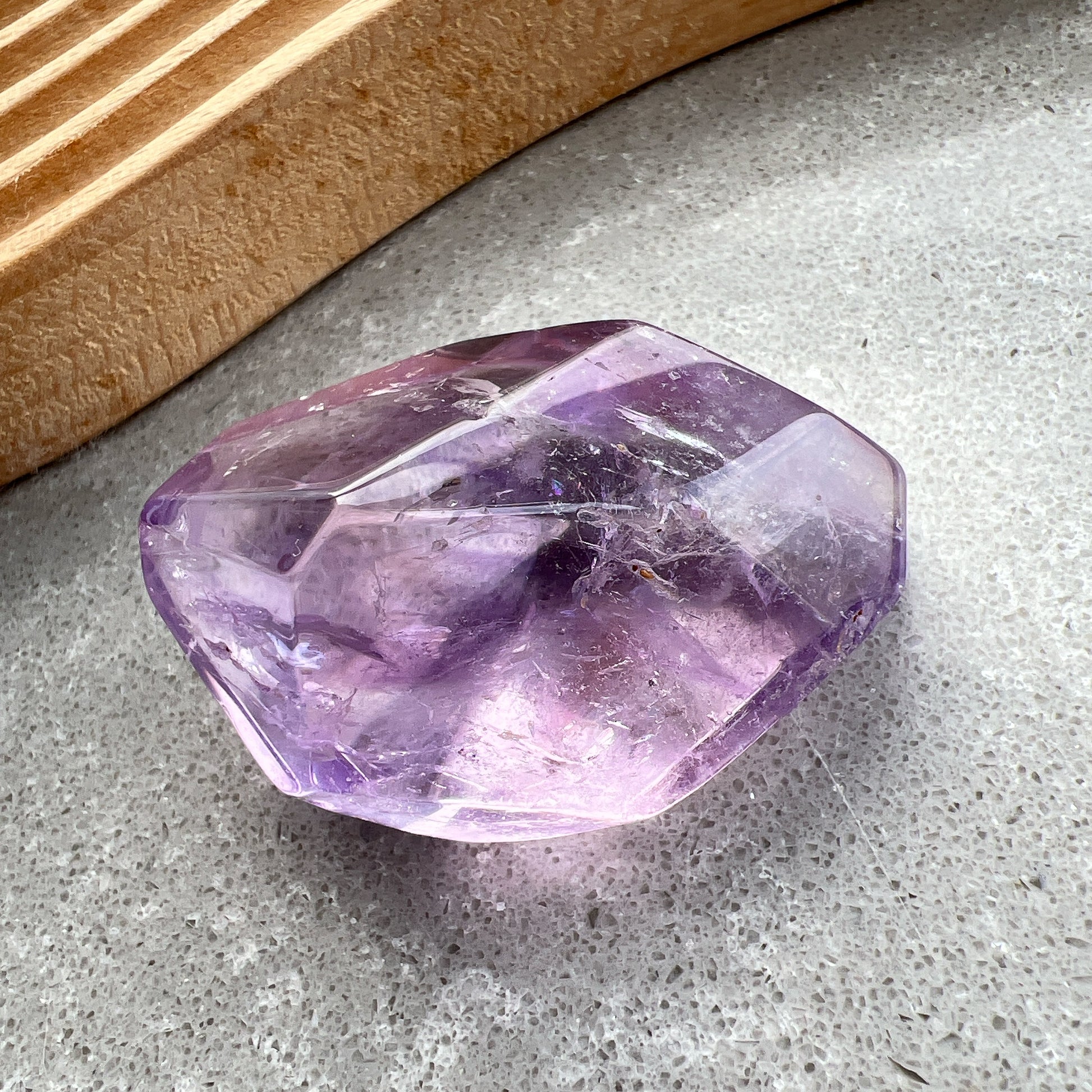 彩虹紫水晶隨形

【 棲於光影間的彩虹 】｜ 紫水晶隨形

這不只是一顆礦石，更像是大自然隨手裁下的一片靜謐光影。

紫水晶深邃且溫柔的色澤，在不規則的隨形切割下，展現出最原始、不經修飾的生命力。當自然光線穿透晶體，內部的天然冰裂縫隙彷彿成了光的稜鏡，在特定角度下綻放出璀璨的彩虹光芒，那是藏在時間深處的驚喜。