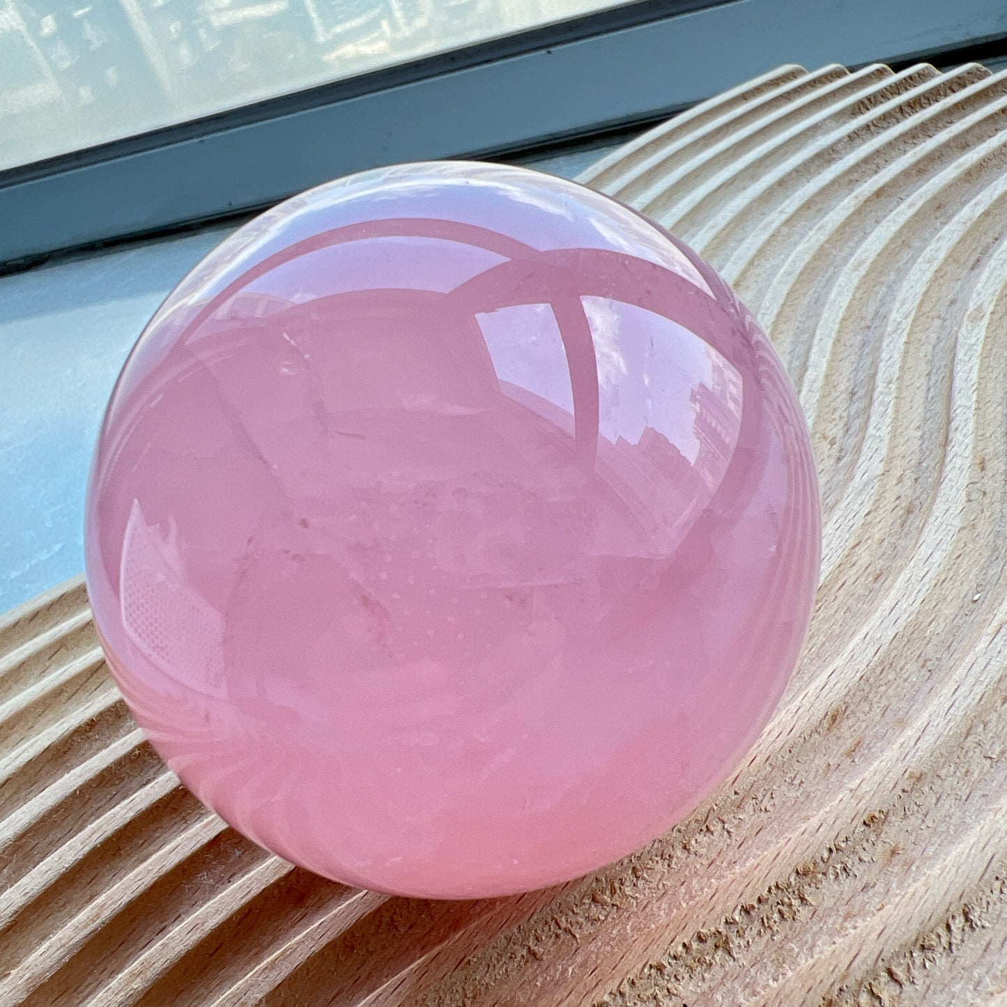星光粉水晶球
凝視那一抹柔粉：讓生活回歸溫柔的本質

家中最迷人的風景，往往來自於自然。這顆粉水晶球不只是裝飾，它是大自然耗費千載凝結出的溫柔色澤。在自然光線的折射下，淡淡的粉色調在球體內交織出如雲霧般的天然冰裂紋與棉旭，每一面都擁有獨一無二的紋理與表情。

比起繁複的裝修，我們更相信「質地」帶來的力量。將它置於床頭、書桌或客廳的一隅，粉水晶柔和的色調能瞬間柔化空間的線條。在繁忙的日常步調中，它像是一個安靜的陪伴者，提醒我們放慢呼吸，感受當下的寧靜。