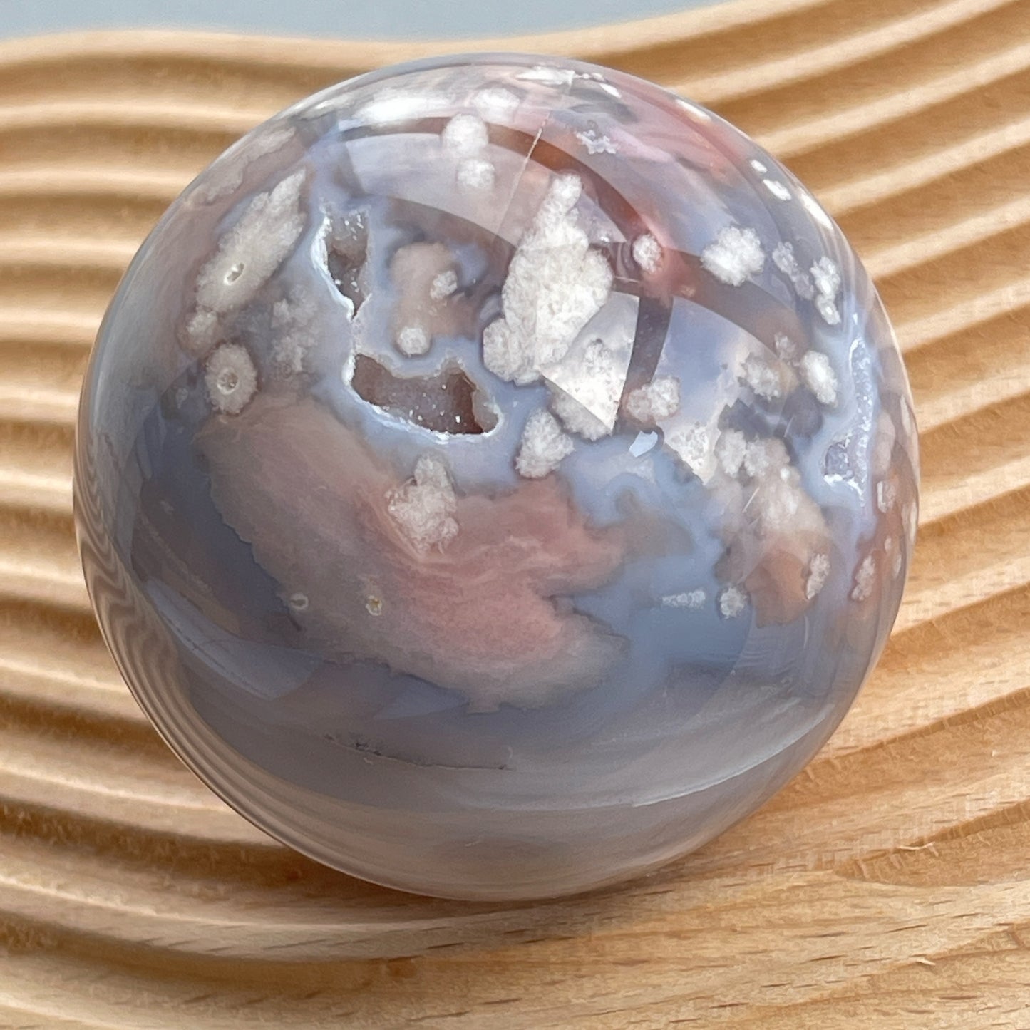 櫻花瑪瑙球  灰藍瑪瑙，nice banding agate , 又有可愛druzy 靚靚晶洞✨  瑪瑙-Agate品種繁多，整個瑪瑙家族十分龐大。其中一種瑪瑙充滿溫柔優雅之美，深受女仕們喜愛，就是櫻花瑪瑙 - Blossoms Agate🌸 櫻花瑪瑙被視為寶石中的「第三眼」，靈性十足，象徵友善與愛心，也代表希望。 櫻花瑪瑙晶體內含粉白色、猶如朵朵盛開之櫻花的共生礦，每枝形態獨一無二，為人帶來溫柔細膩的內涵，會令人要停下來慢慢欣賞佢嘅美。  -能令人精神放鬆，捉升睡眠質素 -瑪瑙具有平衡，穩定及保護的作用 -也是護身符及辟邪物，有保平安功效 -瑪瑙維持身心和諧，增強愛、忠誠及勇氣