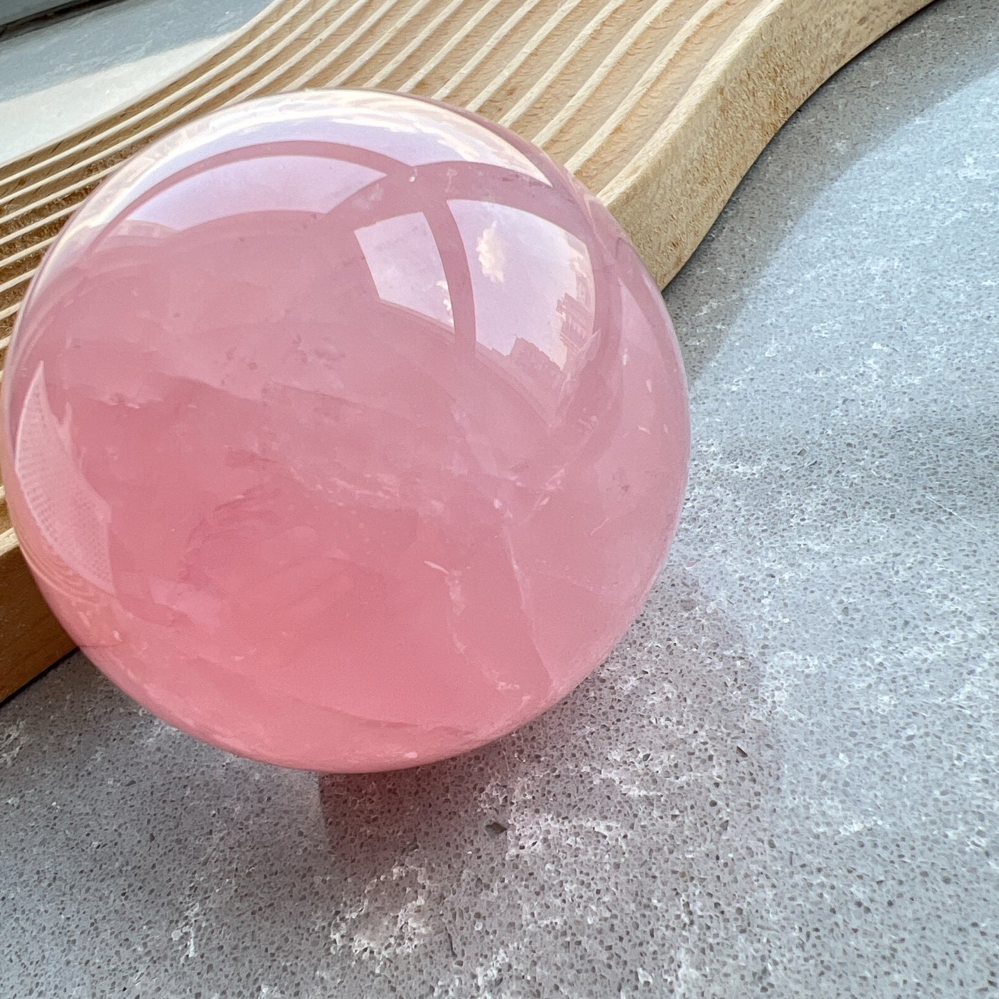 星光粉水晶球
凝視那一抹柔粉：讓生活回歸溫柔的本質

家中最迷人的風景，往往來自於自然。這顆粉水晶球不只是裝飾，它是大自然耗費千載凝結出的溫柔色澤。在自然光線的折射下，淡淡的粉色調在球體內交織出如雲霧般的天然冰裂紋與棉旭，每一面都擁有獨一無二的紋理與表情。

比起繁複的裝修，我們更相信「質地」帶來的力量。將它置於床頭、書桌或客廳的一隅，粉水晶柔和的色調能瞬間柔化空間的線條。在繁忙的日常步調中，它像是一個安靜的陪伴者，提醒我們放慢呼吸，感受當下的寧靜。