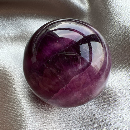 Purple Fluorite Sphere紫紅螢石球  螢石是不可或缺的晶石之一，除左螢石有豐富嘅色彩和好高的觀賞價值之外，放她在工作枱亦都可以時時刻刻緩解煩躁的情緒，有助減低壓力，去除人體積累的負能量，同時亦可以減低電子器材發出的輻射。  -螢石  -幫助頭腦保持清晰  -提升注意力集中  -適合常常用腦ge 朋友同同學仔  紫螢石適合從事思考的工作者，讓思考更敏銳。