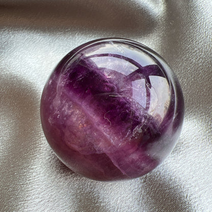 Purple Fluorite Sphere 紫紅螢石球  螢石是不可或缺的晶石之一，除左螢石有豐富嘅色彩和好高的觀賞價值之外，放她在工作枱亦都可以時時刻刻緩解煩躁的情緒，有助減低壓力，去除人體積累的負能量，同時亦可以減低電子器材發出的輻射。  -螢石  -幫助頭腦保持清晰  -提升注意力集中  -適合常常用腦ge 朋友同同學仔  紫螢石適合從事思考的工作者，讓思考更敏銳。