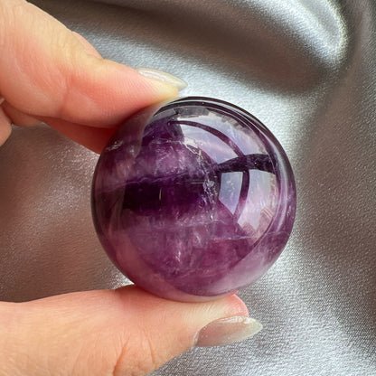 Purple Fluorite Sphere 紫紅螢石球  螢石是不可或缺的晶石之一，除左螢石有豐富嘅色彩和好高的觀賞價值之外，放她在工作枱亦都可以時時刻刻緩解煩躁的情緒，有助減低壓力，去除人體積累的負能量，同時亦可以減低電子器材發出的輻射。  -螢石  -幫助頭腦保持清晰  -提升注意力集中  -適合常常用腦ge 朋友同同學仔  紫螢石適合從事思考的工作者，讓思考更敏銳。