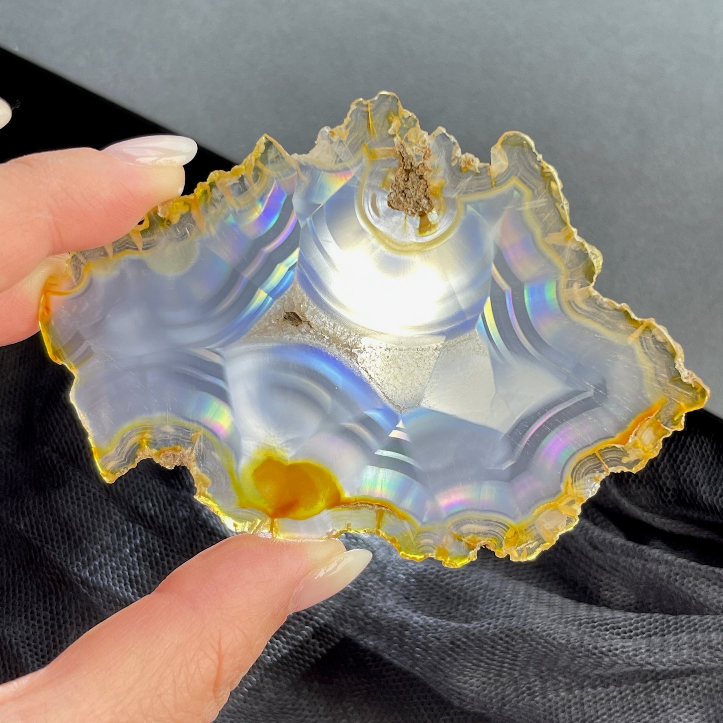 虹彩瑪瑙是一種細帶狀、半透明的石髓 (Chalcedony)，並且可將透射光分解成為光譜顏色。”Iris”意為”彩虹”或”虹彩虹色的”，源自於希臘彩虹女神的名字。  Iris agate is a finely-banded, translucent variety of chalcedony that breaks up transmitted light into spectral colors. The word “Iris” means “rainbow” or “to make iridescent” and is derived from the name of the Greek goddess of the rainbow.     *以上資料轉載自 “GIA Hong Kong - Jul 2021”