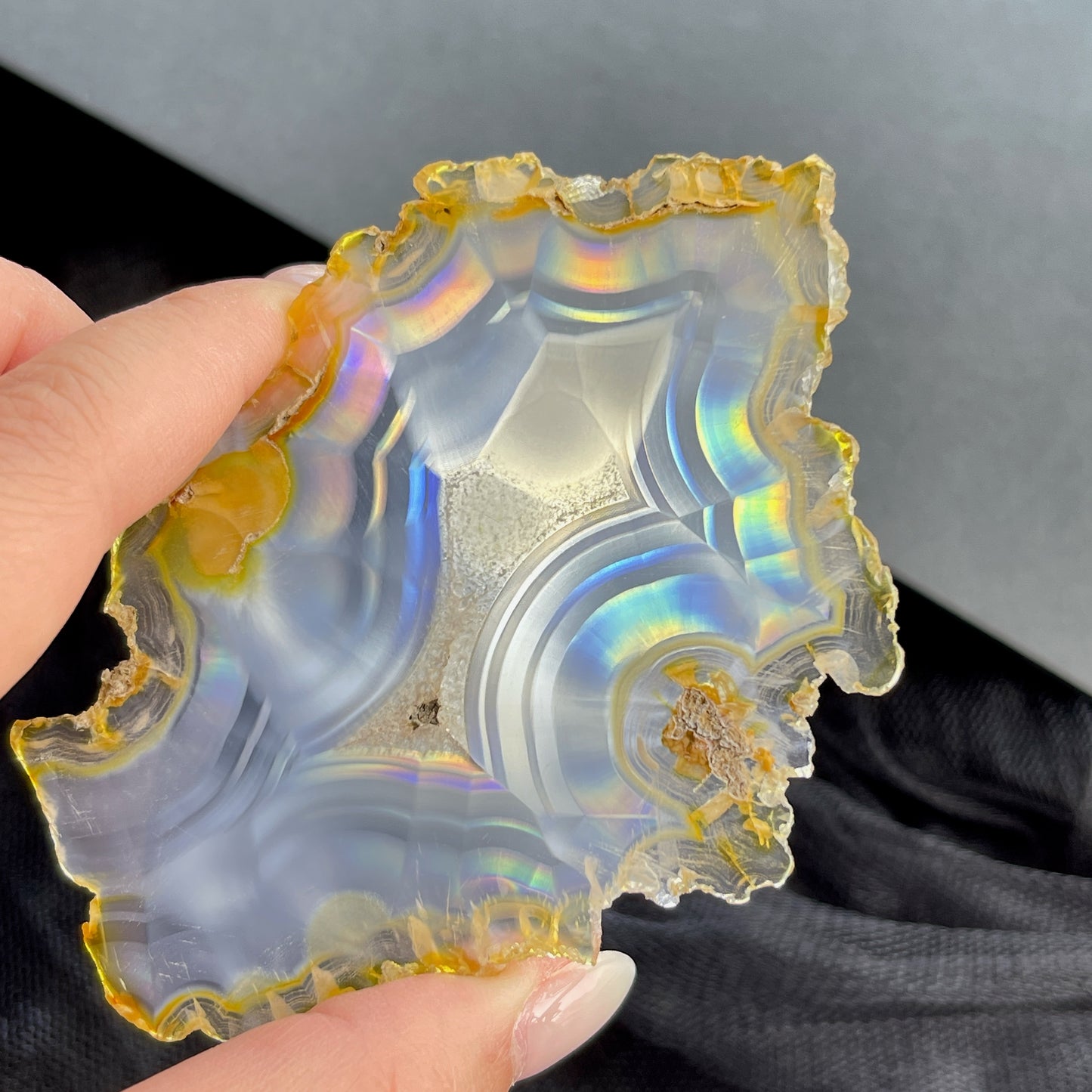 虹彩瑪瑙是一種細帶狀、半透明的石髓 (Chalcedony)，並且可將透射光分解成為光譜顏色。”Iris”意為”彩虹”或”虹彩虹色的”，源自於希臘彩虹女神的名字。  Iris agate is a finely-banded, translucent variety of chalcedony that breaks up transmitted light into spectral colors. The word “Iris” means “rainbow” or “to make iridescent” and is derived from the name of the Greek goddess of the rainbow.     *以上資料轉載自 “GIA Hong Kong - Jul 2021”