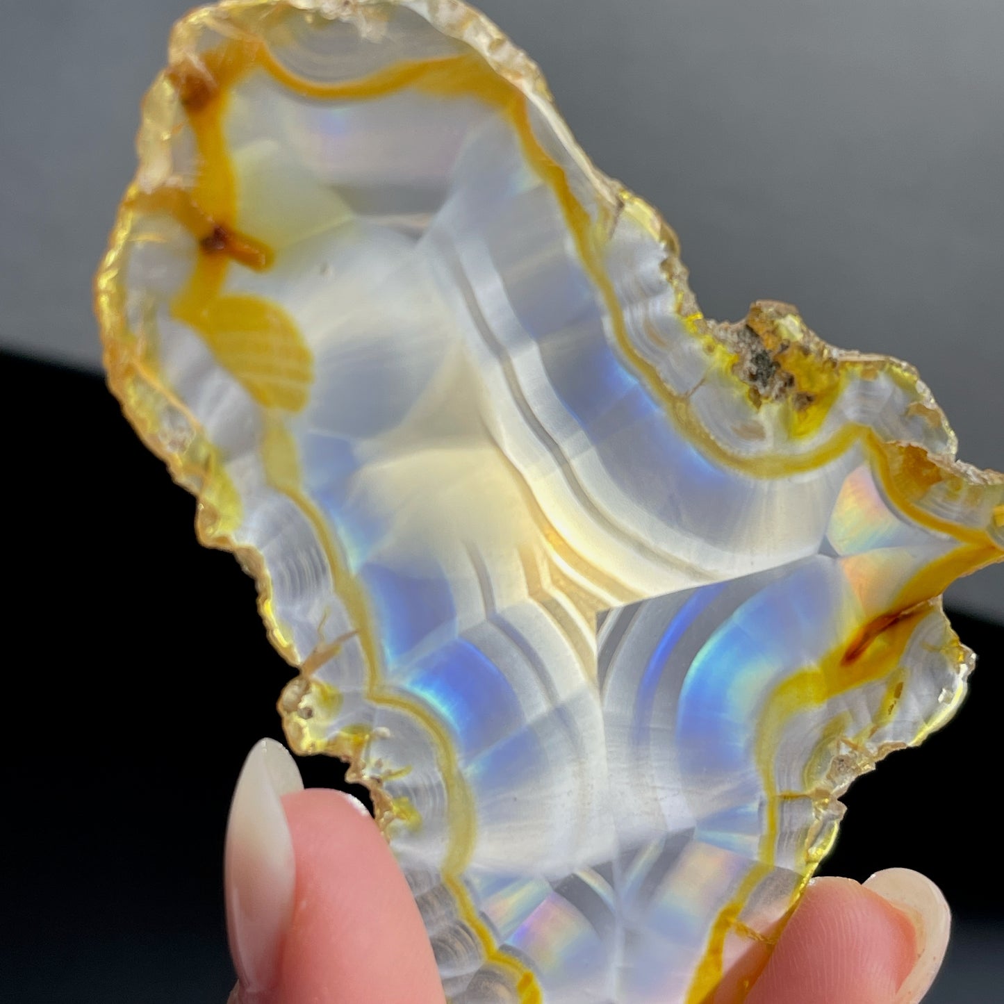 虹彩瑪瑙是一種細帶狀、半透明的石髓 (Chalcedony)，並且可將透射光分解成為光譜顏色。”Iris”意為”彩虹”或”虹彩虹色的”，源自於希臘彩虹女神的名字。  Iris agate is a finely-banded, translucent variety of chalcedony that breaks up transmitted light into spectral colors. The word “Iris” means “rainbow” or “to make iridescent” and is derived from the name of the Greek goddess of the rainbow.     *以上資料轉載自 “GIA Hong Kong - Jul 2021”