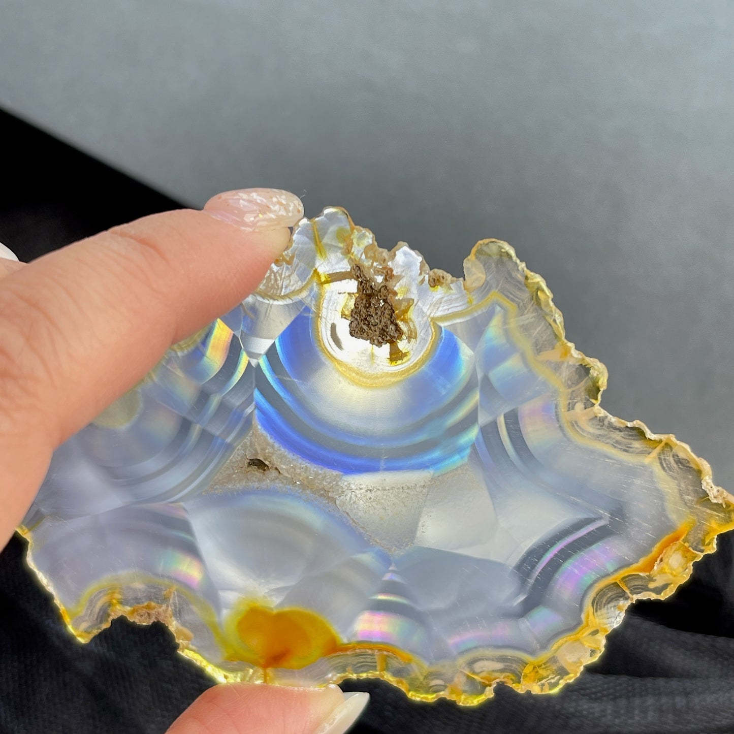 虹彩瑪瑙是一種細帶狀、半透明的石髓 (Chalcedony)，並且可將透射光分解成為光譜顏色。”Iris”意為”彩虹”或”虹彩虹色的”，源自於希臘彩虹女神的名字。  Iris agate is a finely-banded, translucent variety of chalcedony that breaks up transmitted light into spectral colors. The word “Iris” means “rainbow” or “to make iridescent” and is derived from the name of the Greek goddess of the rainbow.     *以上資料轉載自 “GIA Hong Kong - Jul 2021”