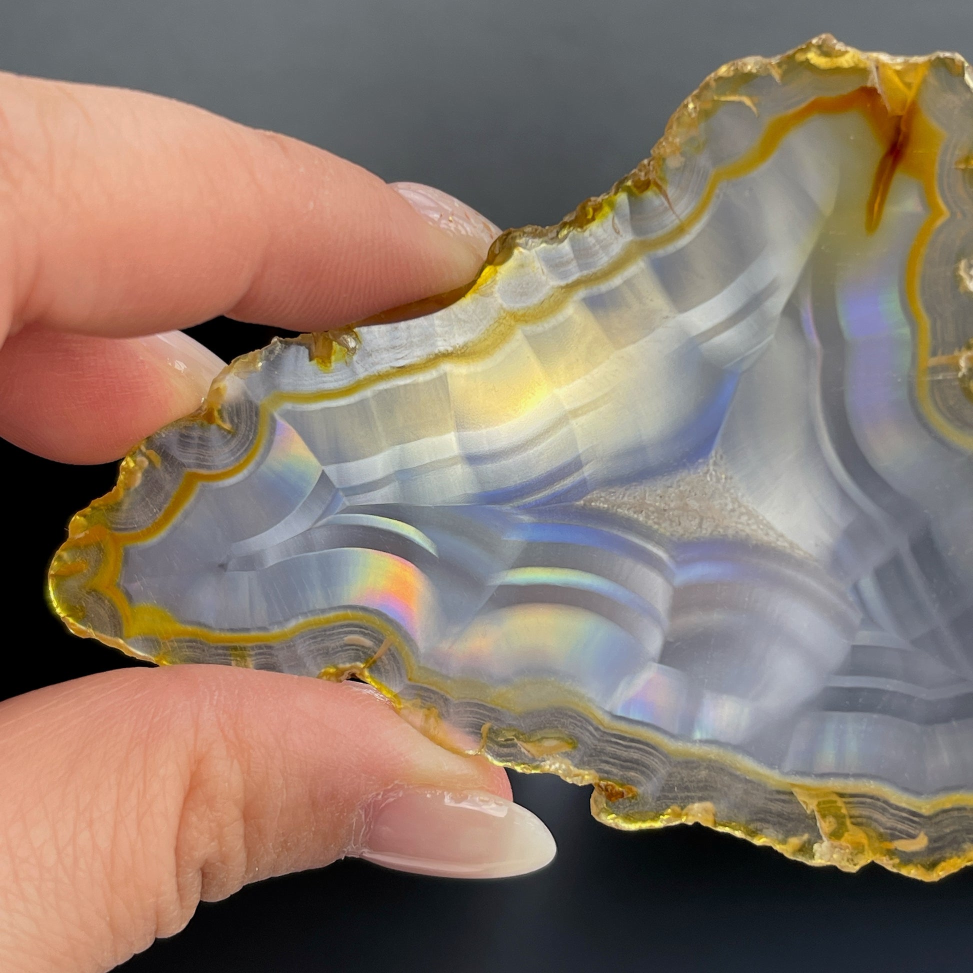 虹彩瑪瑙是一種細帶狀、半透明的石髓 (Chalcedony)，並且可將透射光分解成為光譜顏色。”Iris”意為”彩虹”或”虹彩虹色的”，源自於希臘彩虹女神的名字。  Iris agate is a finely-banded, translucent variety of chalcedony that breaks up transmitted light into spectral colors. The word “Iris” means “rainbow” or “to make iridescent” and is derived from the name of the Greek goddess of the rainbow.     *以上資料轉載自 “GIA Hong Kong - Jul 2021”