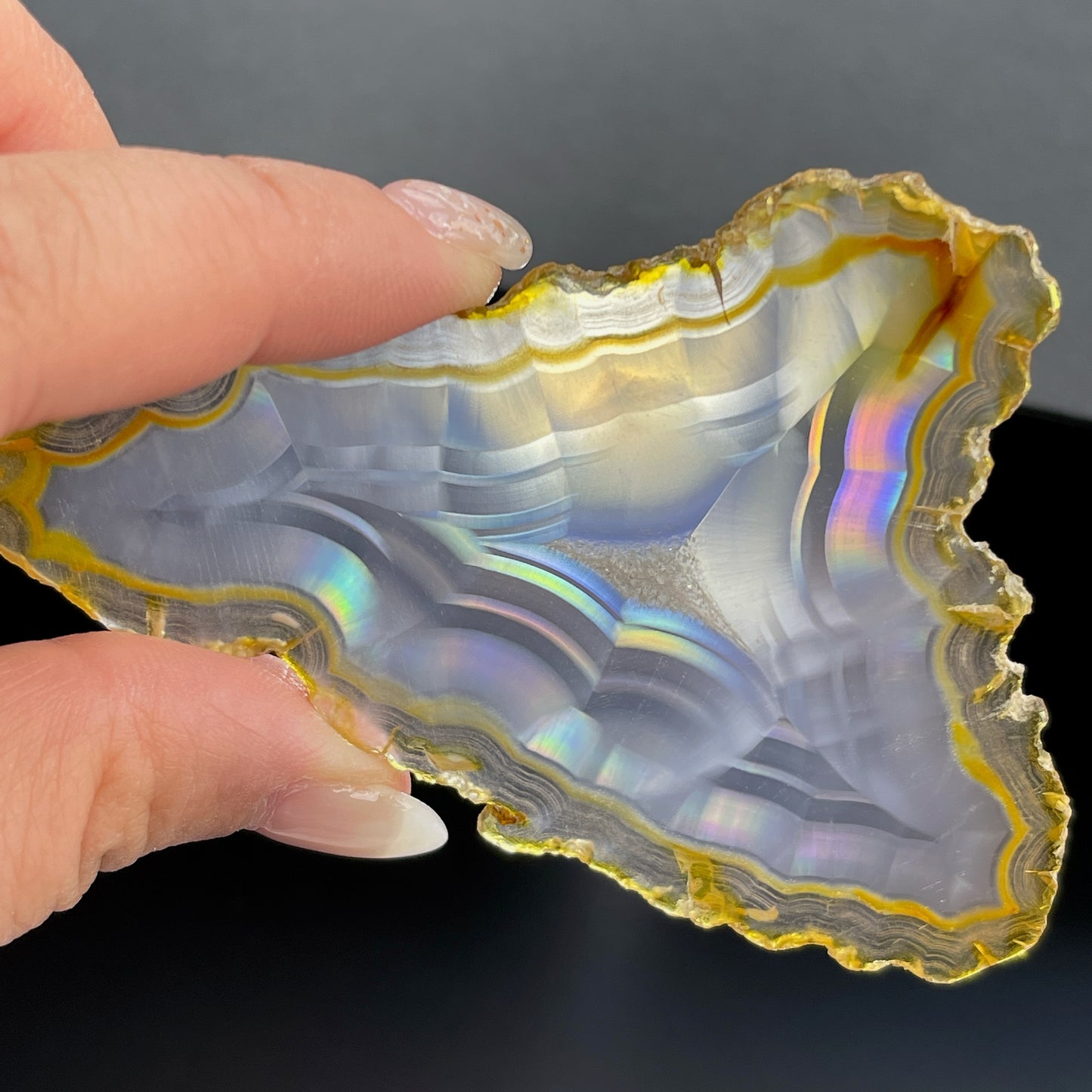 虹彩瑪瑙是一種細帶狀、半透明的石髓 (Chalcedony)，並且可將透射光分解成為光譜顏色。”Iris”意為”彩虹”或”虹彩虹色的”，源自於希臘彩虹女神的名字。  Iris agate is a finely-banded, translucent variety of chalcedony that breaks up transmitted light into spectral colors. The word “Iris” means “rainbow” or “to make iridescent” and is derived from the name of the Greek goddess of the rainbow.     *以上資料轉載自 “GIA Hong Kong - Jul 2021”