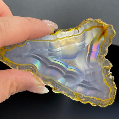 虹彩瑪瑙是一種細帶狀、半透明的石髓 (Chalcedony)，並且可將透射光分解成為光譜顏色。”Iris”意為”彩虹”或”虹彩虹色的”，源自於希臘彩虹女神的名字。  Iris agate is a finely-banded, translucent variety of chalcedony that breaks up transmitted light into spectral colors. The word “Iris” means “rainbow” or “to make iridescent” and is derived from the name of the Greek goddess of the rainbow.     *以上資料轉載自 “GIA Hong Kong - Jul 2021”