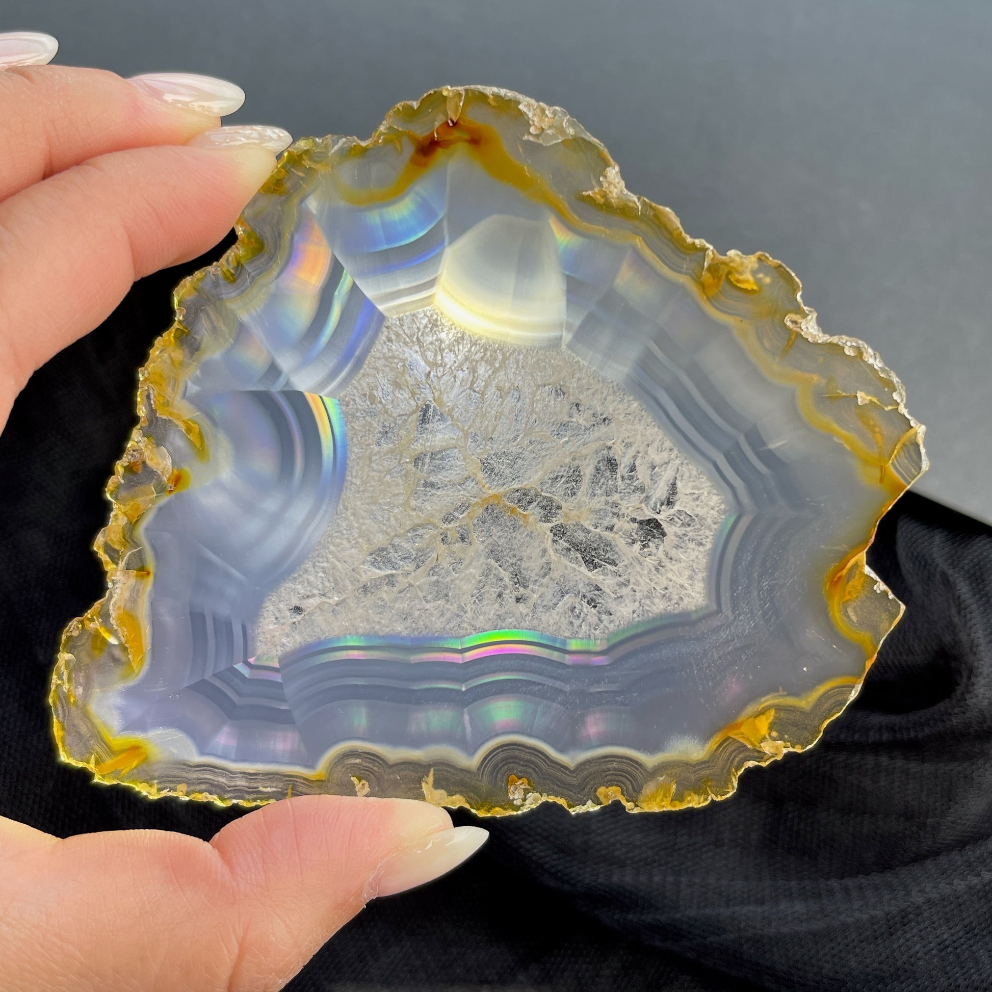 虹彩瑪瑙是一種細帶狀、半透明的石髓 (Chalcedony)，並且可將透射光分解成為光譜顏色。”Iris”意為”彩虹”或”虹彩虹色的”，源自於希臘彩虹女神的名字。  Iris agate is a finely-banded, translucent variety of chalcedony that breaks up transmitted light into spectral colors. The word “Iris” means “rainbow” or “to make iridescent” and is derived from the name of the Greek goddess of the rainbow.     *以上資料轉載自 “GIA Hong Kong - Jul 2021”