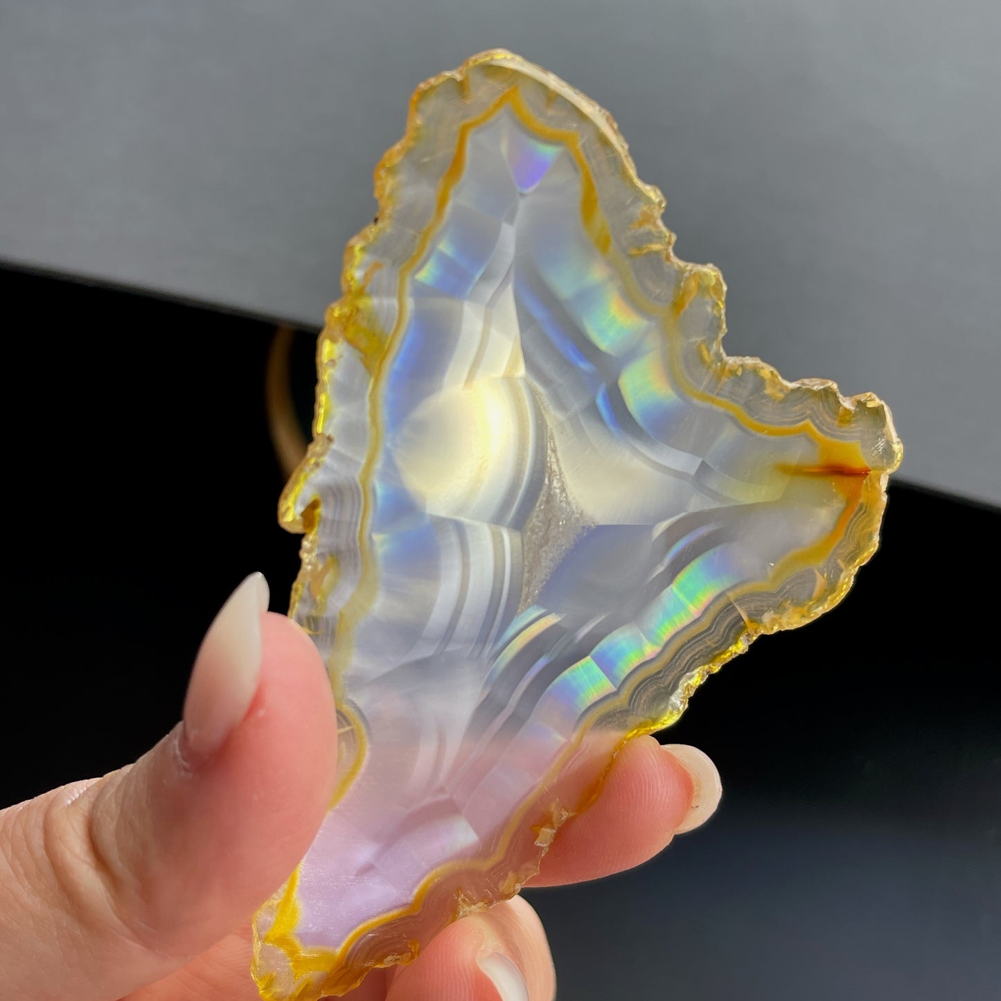 虹彩瑪瑙是一種細帶狀、半透明的石髓 (Chalcedony)，並且可將透射光分解成為光譜顏色。”Iris”意為”彩虹”或”虹彩虹色的”，源自於希臘彩虹女神的名字。  Iris agate is a finely-banded, translucent variety of chalcedony that breaks up transmitted light into spectral colors. The word “Iris” means “rainbow” or “to make iridescent” and is derived from the name of the Greek goddess of the rainbow.     *以上資料轉載自 “GIA Hong Kong - Jul 2021”