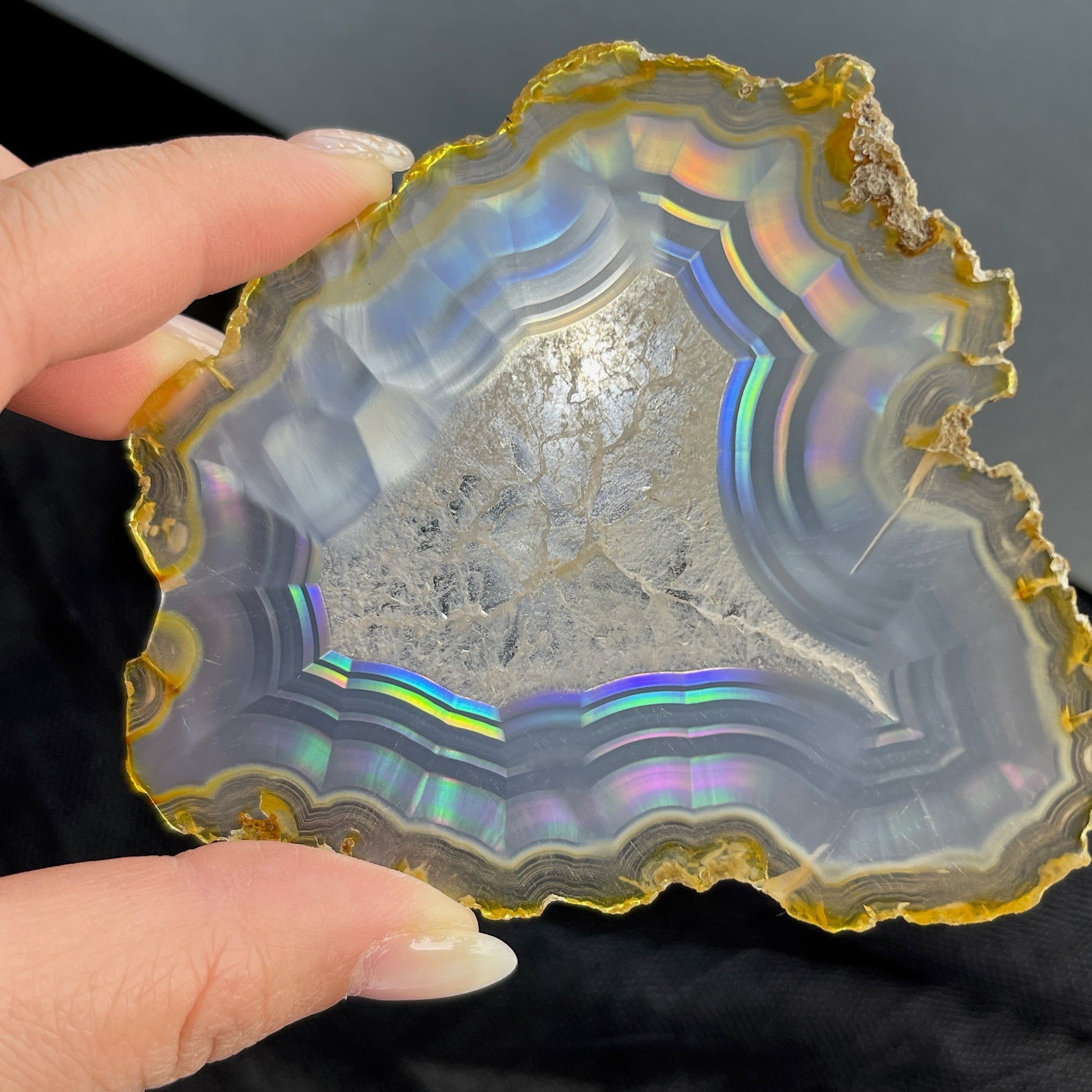 虹彩瑪瑙是一種細帶狀、半透明的石髓 (Chalcedony)，並且可將透射光分解成為光譜顏色。”Iris”意為”彩虹”或”虹彩虹色的”，源自於希臘彩虹女神的名字。  Iris agate is a finely-banded, translucent variety of chalcedony that breaks up transmitted light into spectral colors. The word “Iris” means “rainbow” or “to make iridescent” and is derived from the name of the Greek goddess of the rainbow.     *以上資料轉載自 “GIA Hong Kong - Jul 2021”