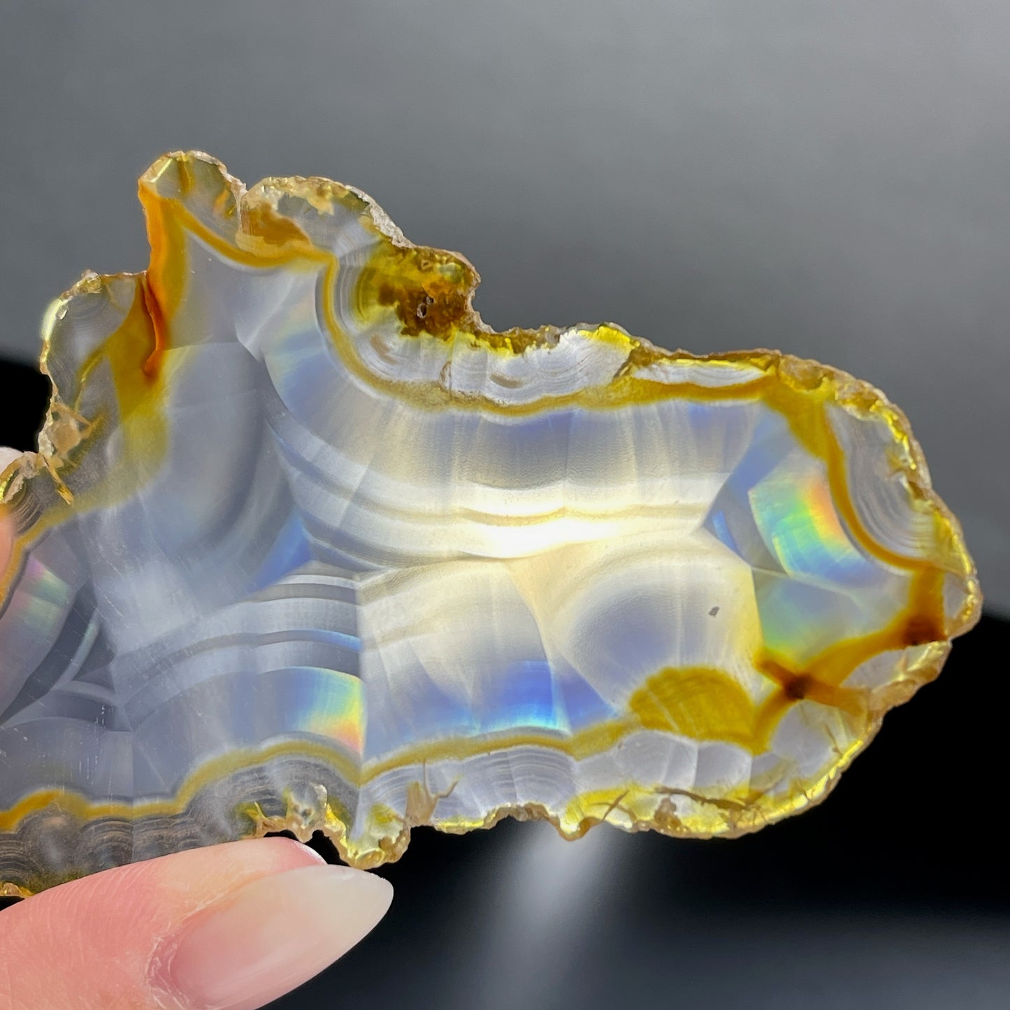 虹彩瑪瑙是一種細帶狀、半透明的石髓 (Chalcedony)，並且可將透射光分解成為光譜顏色。”Iris”意為”彩虹”或”虹彩虹色的”，源自於希臘彩虹女神的名字。  Iris agate is a finely-banded, translucent variety of chalcedony that breaks up transmitted light into spectral colors. The word “Iris” means “rainbow” or “to make iridescent” and is derived from the name of the Greek goddess of the rainbow.     *以上資料轉載自 “GIA Hong Kong - Jul 2021”