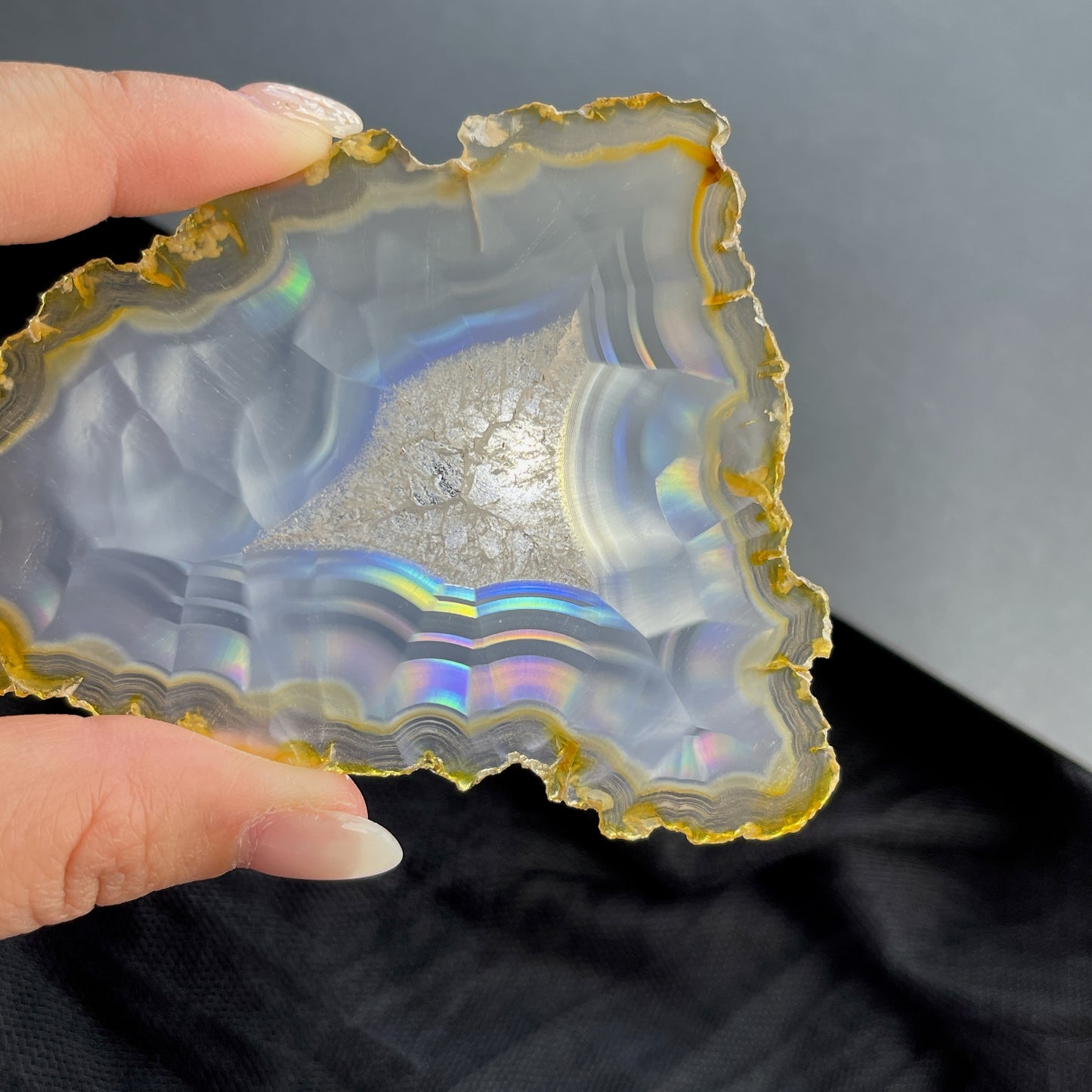 虹彩瑪瑙是一種細帶狀、半透明的石髓 (Chalcedony)，並且可將透射光分解成為光譜顏色。”Iris”意為”彩虹”或”虹彩虹色的”，源自於希臘彩虹女神的名字。  Iris agate is a finely-banded, translucent variety of chalcedony that breaks up transmitted light into spectral colors. The word “Iris” means “rainbow” or “to make iridescent” and is derived from the name of the Greek goddess of the rainbow.     *以上資料轉載自 “GIA Hong Kong - Jul 2021”