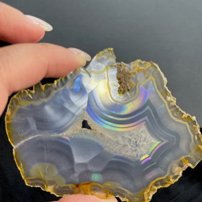 虹彩瑪瑙是一種細帶狀、半透明的石髓 (Chalcedony)，並且可將透射光分解成為光譜顏色。”Iris”意為”彩虹”或”虹彩虹色的”，源自於希臘彩虹女神的名字。  Iris agate is a finely-banded, translucent variety of chalcedony that breaks up transmitted light into spectral colors. The word “Iris” means “rainbow” or “to make iridescent” and is derived from the name of the Greek goddess of the rainbow.     *以上資料轉載自 “GIA Hong Kong - Jul 2021”