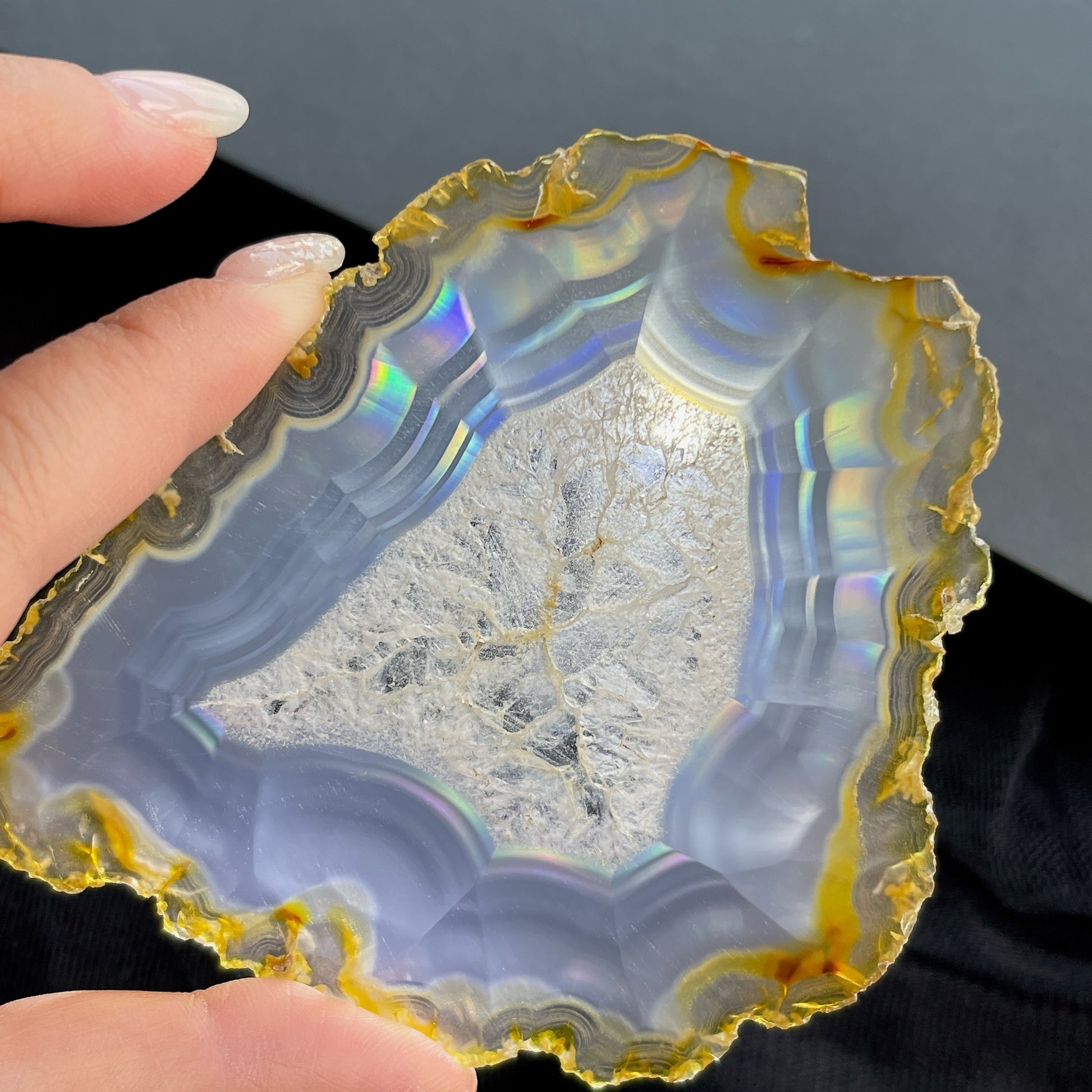 虹彩瑪瑙是一種細帶狀、半透明的石髓 (Chalcedony)，並且可將透射光分解成為光譜顏色。”Iris”意為”彩虹”或”虹彩虹色的”，源自於希臘彩虹女神的名字。  Iris agate is a finely-banded, translucent variety of chalcedony that breaks up transmitted light into spectral colors. The word “Iris” means “rainbow” or “to make iridescent” and is derived from the name of the Greek goddess of the rainbow.     *以上資料轉載自 “GIA Hong Kong - Jul 2021”