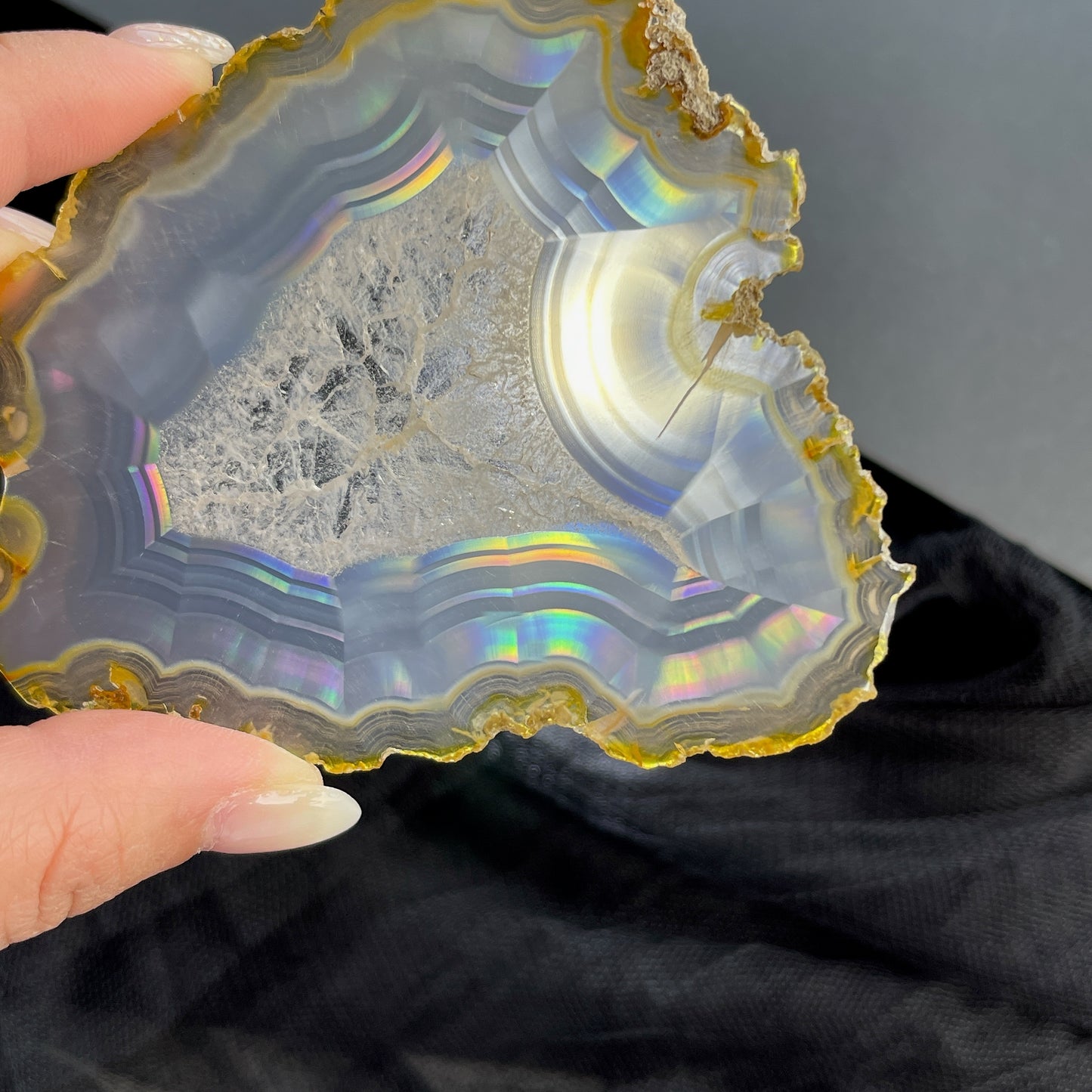 虹彩瑪瑙是一種細帶狀、半透明的石髓 (Chalcedony)，並且可將透射光分解成為光譜顏色。”Iris”意為”彩虹”或”虹彩虹色的”，源自於希臘彩虹女神的名字。  Iris agate is a finely-banded, translucent variety of chalcedony that breaks up transmitted light into spectral colors. The word “Iris” means “rainbow” or “to make iridescent” and is derived from the name of the Greek goddess of the rainbow.     *以上資料轉載自 “GIA Hong Kong - Jul 2021”