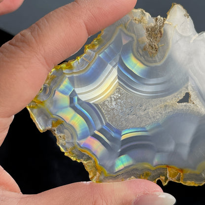 虹彩瑪瑙是一種細帶狀、半透明的石髓 (Chalcedony)，並且可將透射光分解成為光譜顏色。”Iris”意為”彩虹”或”虹彩虹色的”，源自於希臘彩虹女神的名字。  Iris agate is a finely-banded, translucent variety of chalcedony that breaks up transmitted light into spectral colors. The word “Iris” means “rainbow” or “to make iridescent” and is derived from the name of the Greek goddess of the rainbow.     *以上資料轉載自 “GIA Hong Kong - Jul 2021”