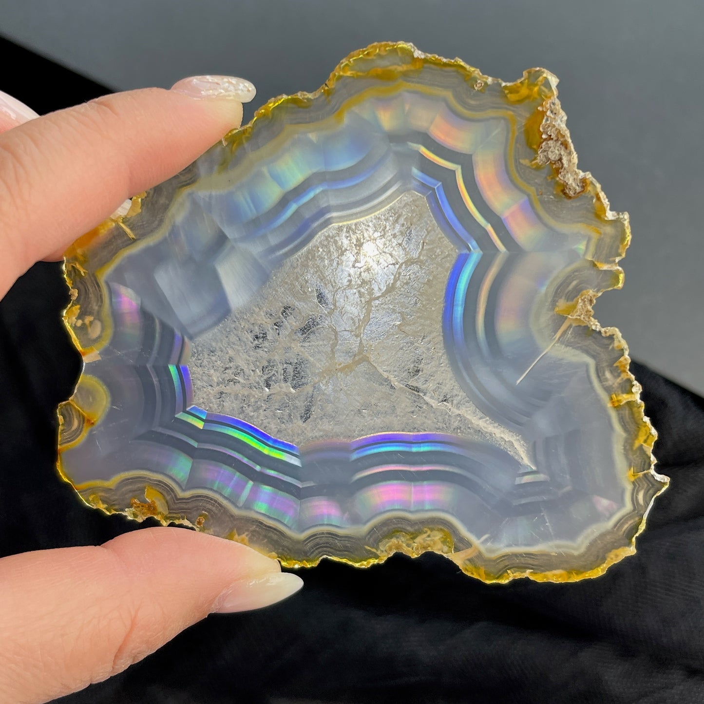 虹彩瑪瑙是一種細帶狀、半透明的石髓 (Chalcedony)，並且可將透射光分解成為光譜顏色。”Iris”意為”彩虹”或”虹彩虹色的”，源自於希臘彩虹女神的名字。  Iris agate is a finely-banded, translucent variety of chalcedony that breaks up transmitted light into spectral colors. The word “Iris” means “rainbow” or “to make iridescent” and is derived from the name of the Greek goddess of the rainbow.     *以上資料轉載自 “GIA Hong Kong - Jul 2021”