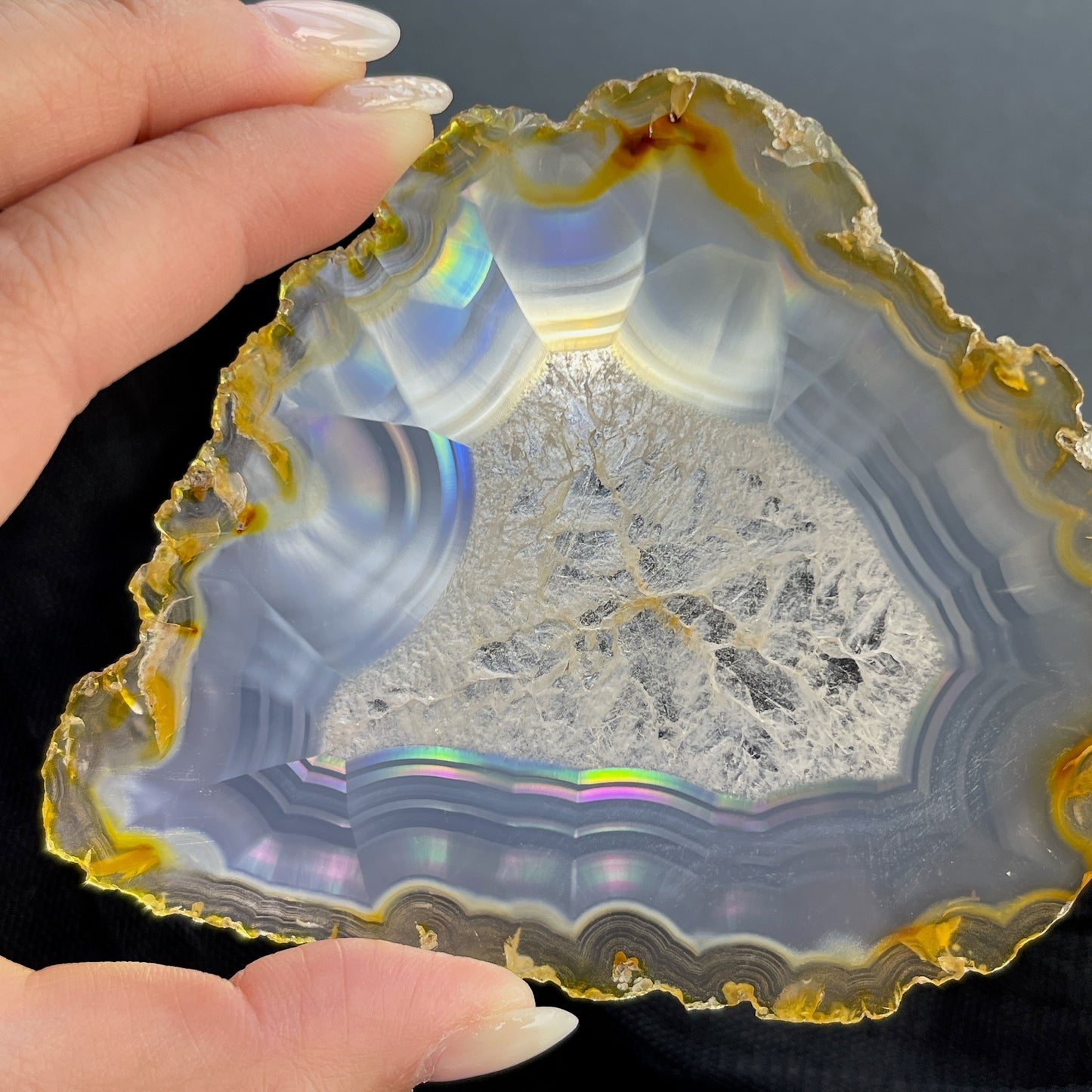 虹彩瑪瑙是一種細帶狀、半透明的石髓 (Chalcedony)，並且可將透射光分解成為光譜顏色。”Iris”意為”彩虹”或”虹彩虹色的”，源自於希臘彩虹女神的名字。  Iris agate is a finely-banded, translucent variety of chalcedony that breaks up transmitted light into spectral colors. The word “Iris” means “rainbow” or “to make iridescent” and is derived from the name of the Greek goddess of the rainbow.     *以上資料轉載自 “GIA Hong Kong - Jul 2021”