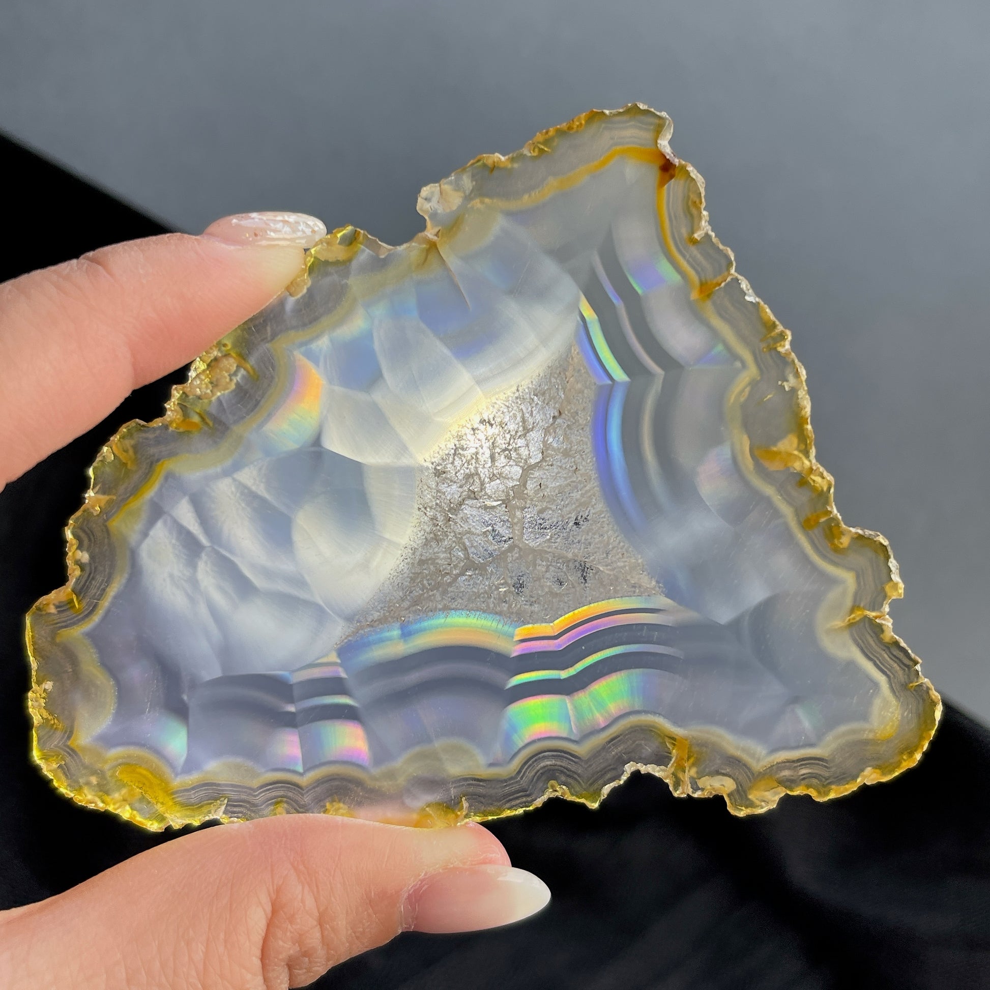 虹彩瑪瑙是一種細帶狀、半透明的石髓 (Chalcedony)，並且可將透射光分解成為光譜顏色。”Iris”意為”彩虹”或”虹彩虹色的”，源自於希臘彩虹女神的名字。  Iris agate is a finely-banded, translucent variety of chalcedony that breaks up transmitted light into spectral colors. The word “Iris” means “rainbow” or “to make iridescent” and is derived from the name of the Greek goddess of the rainbow.     *以上資料轉載自 “GIA Hong Kong - Jul 2021”