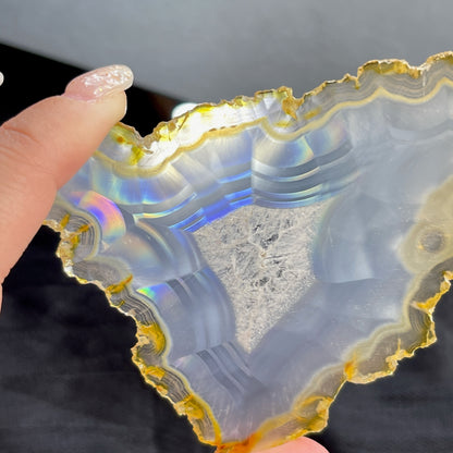 虹彩瑪瑙是一種細帶狀、半透明的石髓 (Chalcedony)，並且可將透射光分解成為光譜顏色。”Iris”意為”彩虹”或”虹彩虹色的”，源自於希臘彩虹女神的名字。  Iris agate is a finely-banded, translucent variety of chalcedony that breaks up transmitted light into spectral colors. The word “Iris” means “rainbow” or “to make iridescent” and is derived from the name of the Greek goddess of the rainbow.     *以上資料轉載自 “GIA Hong Kong - Jul 2021”