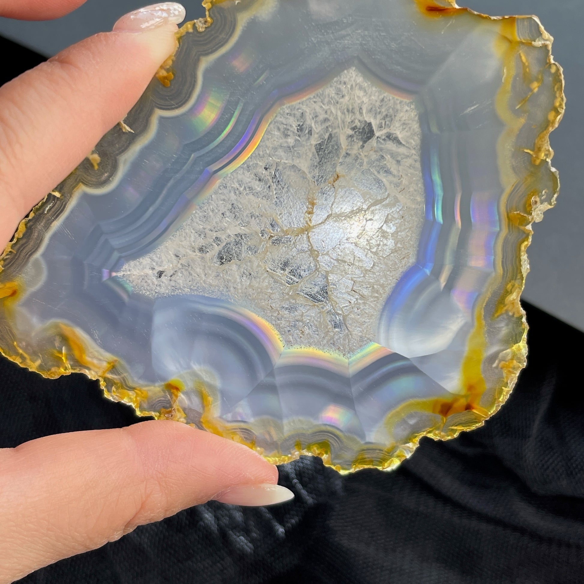 虹彩瑪瑙是一種細帶狀、半透明的石髓 (Chalcedony)，並且可將透射光分解成為光譜顏色。”Iris”意為”彩虹”或”虹彩虹色的”，源自於希臘彩虹女神的名字。  Iris agate is a finely-banded, translucent variety of chalcedony that breaks up transmitted light into spectral colors. The word “Iris” means “rainbow” or “to make iridescent” and is derived from the name of the Greek goddess of the rainbow.     *以上資料轉載自 “GIA Hong Kong - Jul 2021”