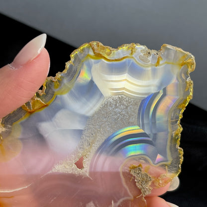 虹彩瑪瑙是一種細帶狀、半透明的石髓 (Chalcedony)，並且可將透射光分解成為光譜顏色。”Iris”意為”彩虹”或”虹彩虹色的”，源自於希臘彩虹女神的名字。  Iris agate is a finely-banded, translucent variety of chalcedony that breaks up transmitted light into spectral colors. The word “Iris” means “rainbow” or “to make iridescent” and is derived from the name of the Greek goddess of the rainbow.     *以上資料轉載自 “GIA Hong Kong - Jul 2021”