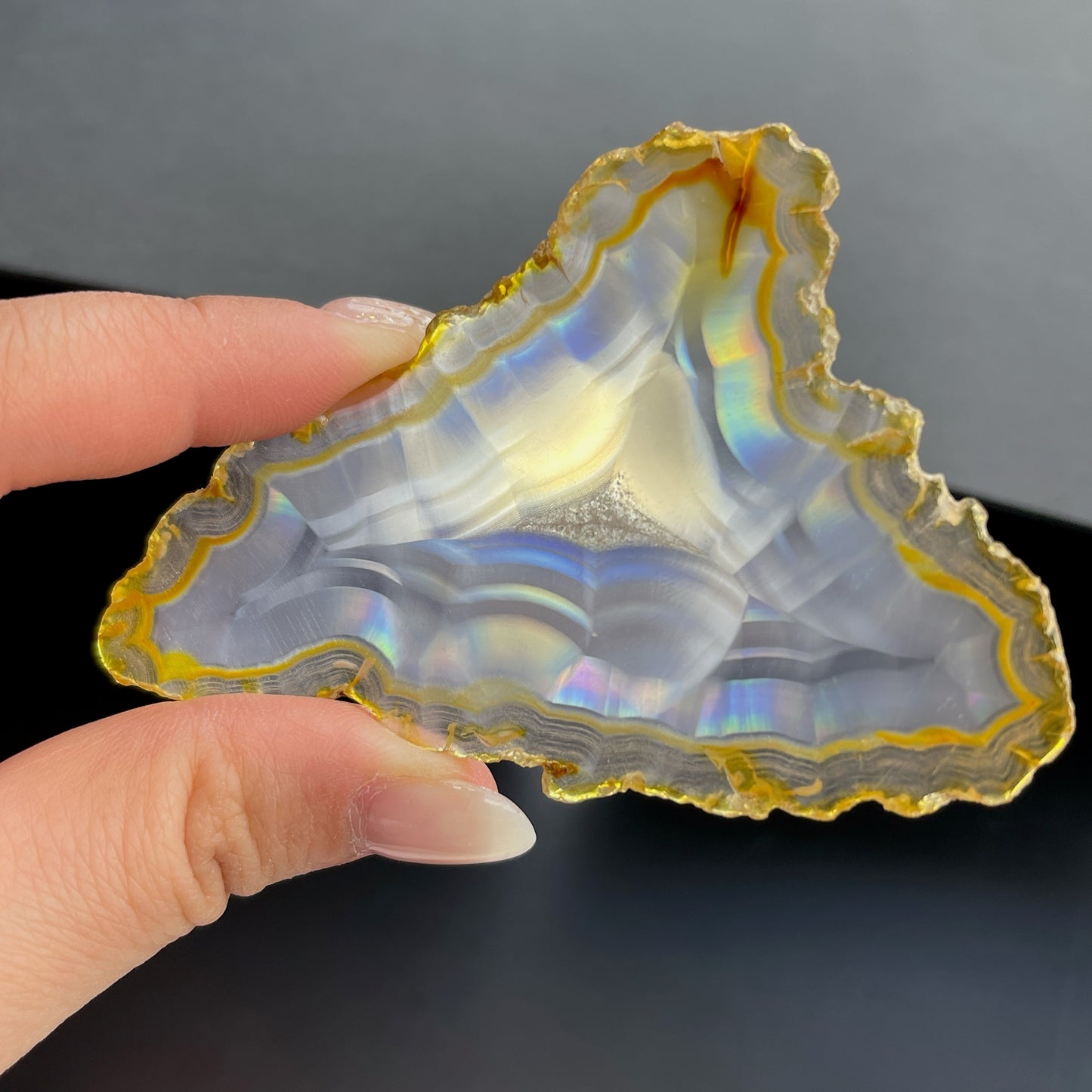 虹彩瑪瑙是一種細帶狀、半透明的石髓 (Chalcedony)，並且可將透射光分解成為光譜顏色。”Iris”意為”彩虹”或”虹彩虹色的”，源自於希臘彩虹女神的名字。  Iris agate is a finely-banded, translucent variety of chalcedony that breaks up transmitted light into spectral colors. The word “Iris” means “rainbow” or “to make iridescent” and is derived from the name of the Greek goddess of the rainbow.     *以上資料轉載自 “GIA Hong Kong - Jul 2021”