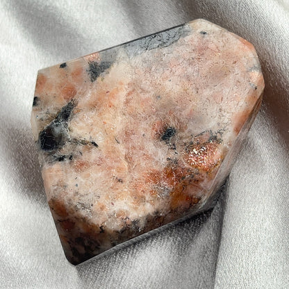  太陽石堇青石共生隨形  Sunstone Iolite  太陽石堇青石結合了Sunstone的溫暖喜悅和Iolite的涼爽平靜，幫助我們看到可能性。當生活感覺混亂，他能幫助我們重新接地並冷靜地評估情況。而且激活了我們解決問題的技能，鼓勵邏輯和直覺思維，帶來新的視角。太陽石堇青石推薦給任何想在身心上更健康的人，幫助我們養成健康的習慣並持開放態度。