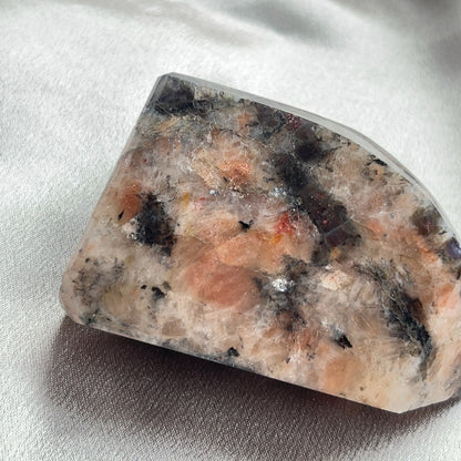  太陽石堇青石共生隨形  Sunstone Iolite  太陽石堇青石結合了Sunstone的溫暖喜悅和Iolite的涼爽平靜，幫助我們看到可能性。當生活感覺混亂，他能幫助我們重新接地並冷靜地評估情況。而且激活了我們解決問題的技能，鼓勵邏輯和直覺思維，帶來新的視角。太陽石堇青石推薦給任何想在身心上更健康的人，幫助我們養成健康的習慣並持開放態度。