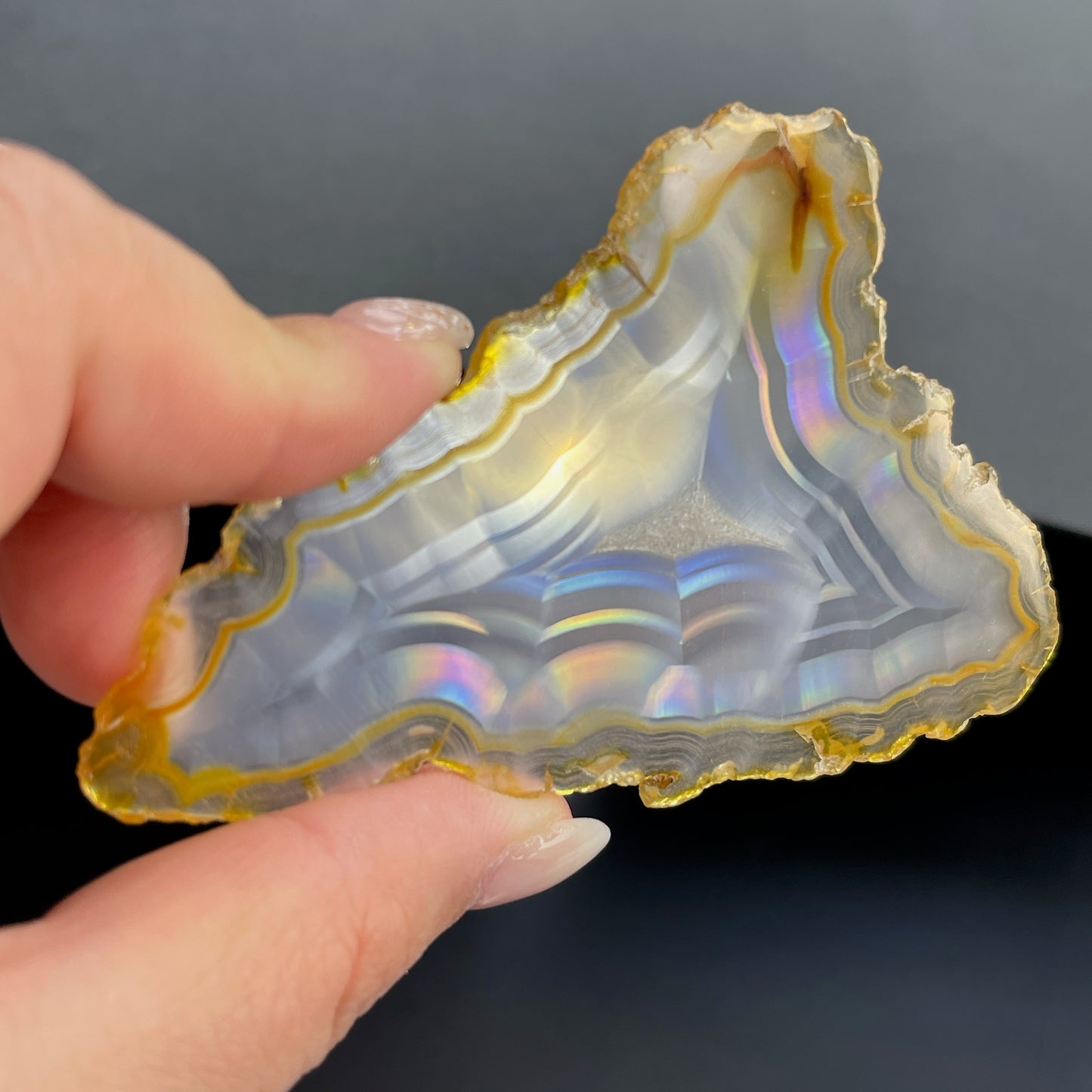 虹彩瑪瑙是一種細帶狀、半透明的石髓 (Chalcedony)，並且可將透射光分解成為光譜顏色。”Iris”意為”彩虹”或”虹彩虹色的”，源自於希臘彩虹女神的名字。  Iris agate is a finely-banded, translucent variety of chalcedony that breaks up transmitted light into spectral colors. The word “Iris” means “rainbow” or “to make iridescent” and is derived from the name of the Greek goddess of the rainbow.     *以上資料轉載自 “GIA Hong Kong - Jul 2021”