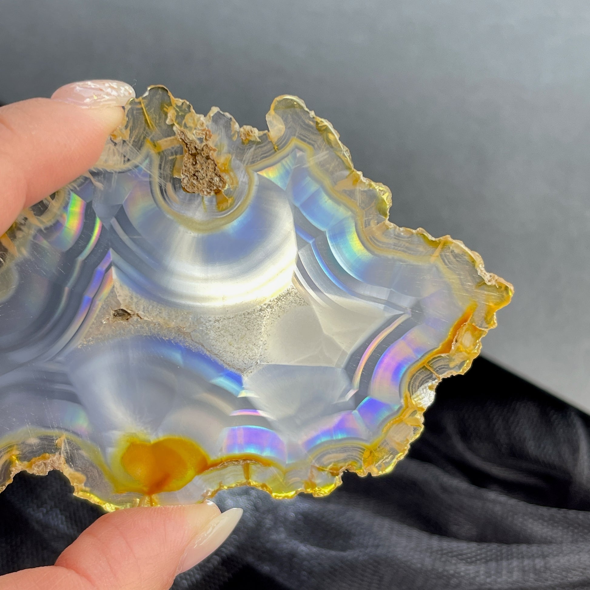 虹彩瑪瑙是一種細帶狀、半透明的石髓 (Chalcedony)，並且可將透射光分解成為光譜顏色。”Iris”意為”彩虹”或”虹彩虹色的”，源自於希臘彩虹女神的名字。  Iris agate is a finely-banded, translucent variety of chalcedony that breaks up transmitted light into spectral colors. The word “Iris” means “rainbow” or “to make iridescent” and is derived from the name of the Greek goddess of the rainbow.     *以上資料轉載自 “GIA Hong Kong - Jul 2021”