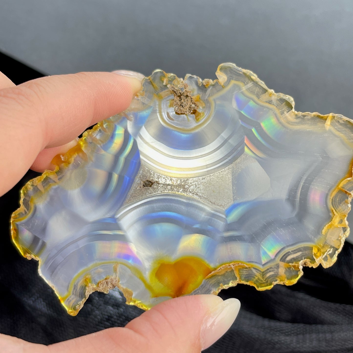 虹彩瑪瑙是一種細帶狀、半透明的石髓 (Chalcedony)，並且可將透射光分解成為光譜顏色。”Iris”意為”彩虹”或”虹彩虹色的”，源自於希臘彩虹女神的名字。  Iris agate is a finely-banded, translucent variety of chalcedony that breaks up transmitted light into spectral colors. The word “Iris” means “rainbow” or “to make iridescent” and is derived from the name of the Greek goddess of the rainbow.     *以上資料轉載自 “GIA Hong Kong - Jul 2021”