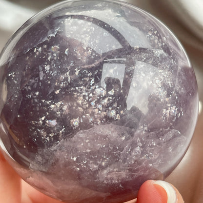 紫螢石共生雲母球  這個是一個一半淡一半深紫的，也算是個千層，佢兩面都是好閃好靚嘅雲母，加埋一齊就好似星空一樣。   螢石是不可或缺的晶石之一，除左螢石有豐富嘅色彩和好高的觀賞價值之外，放她在工作枱亦都可以時時刻刻緩解煩躁的情緒，有助減低壓力，去除人體積累的負能量，同時亦可以減低電子器材發出的輻射。  螢石  -幫助頭腦保持清晰  -提升注意力集中  -適合常常用腦ge 朋友同同學仔  紫螢石適合從事思考的工作者，讓思考更敏銳。     *當中有部分相片和片段尾段是打燈效果