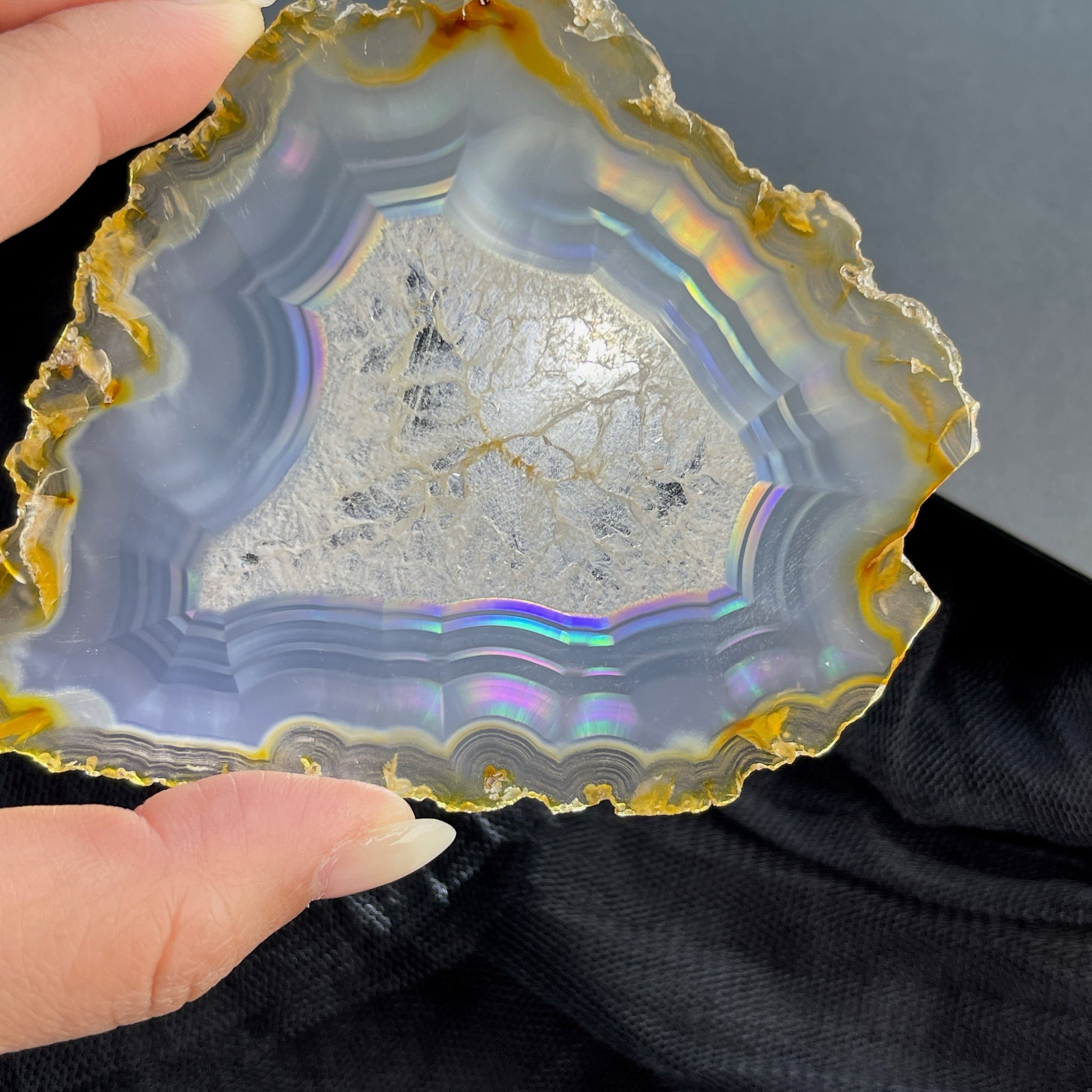 虹彩瑪瑙是一種細帶狀、半透明的石髓 (Chalcedony)，並且可將透射光分解成為光譜顏色。”Iris”意為”彩虹”或”虹彩虹色的”，源自於希臘彩虹女神的名字。  Iris agate is a finely-banded, translucent variety of chalcedony that breaks up transmitted light into spectral colors. The word “Iris” means “rainbow” or “to make iridescent” and is derived from the name of the Greek goddess of the rainbow.     *以上資料轉載自 “GIA Hong Kong - Jul 2021”