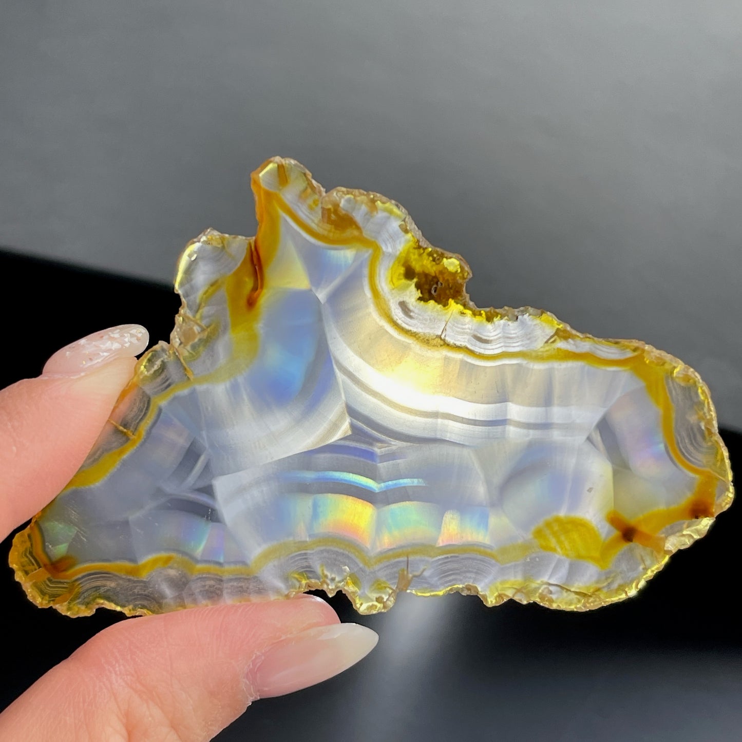 虹彩瑪瑙是一種細帶狀、半透明的石髓 (Chalcedony)，並且可將透射光分解成為光譜顏色。”Iris”意為”彩虹”或”虹彩虹色的”，源自於希臘彩虹女神的名字。  Iris agate is a finely-banded, translucent variety of chalcedony that breaks up transmitted light into spectral colors. The word “Iris” means “rainbow” or “to make iridescent” and is derived from the name of the Greek goddess of the rainbow.     *以上資料轉載自 “GIA Hong Kong - Jul 2021”