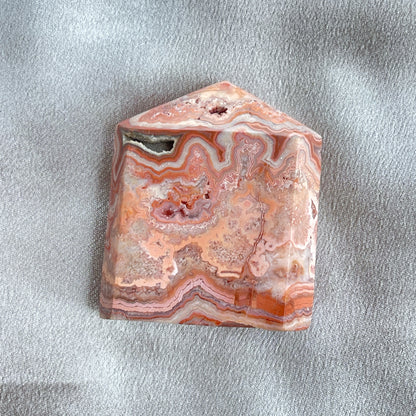 粉色瘋狂蕾絲瑪瑙柱，每一枝都有其獨特而華麗的粉紅色蕾絲紋理。  Pink crazy lace agate是一種多彩的瑪瑙，通常呈粉紅色，並有白色、灰色、黃色等顏色的斑紋。它的名字“crazy lace”意指其形狀和斑紋猶如瘋狂的迴線，非常有趣。Pink crazy lace agate被認為具有平衡、和諧和穩定情緒的功效。它也被視為一種有助於增強信心、勇氣和行動力的水晶，有助於消除負面情緒，增加正能量。   