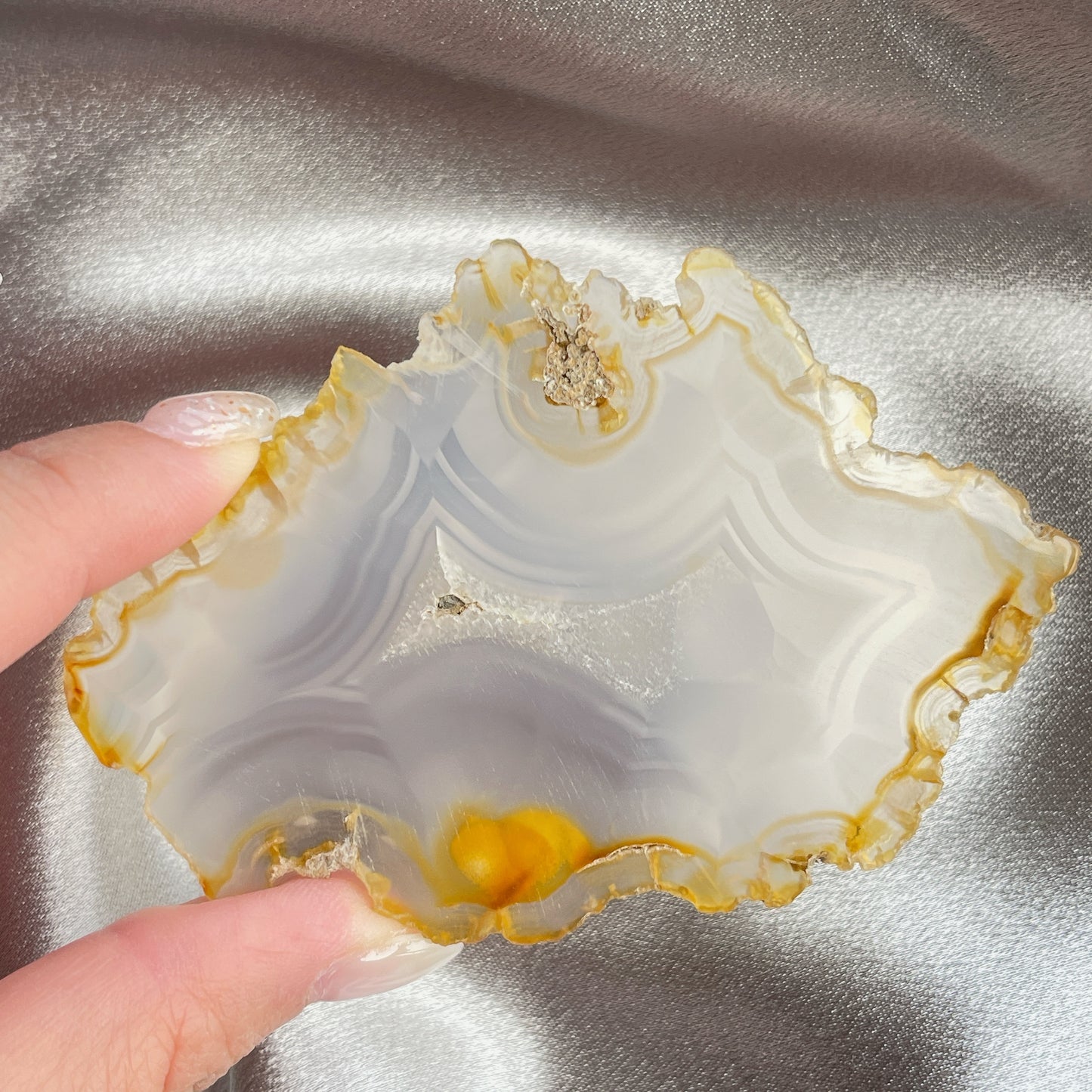 虹彩瑪瑙是一種細帶狀、半透明的石髓 (Chalcedony)，並且可將透射光分解成為光譜顏色。”Iris”意為”彩虹”或”虹彩虹色的”，源自於希臘彩虹女神的名字。  Iris agate is a finely-banded, translucent variety of chalcedony that breaks up transmitted light into spectral colors. The word “Iris” means “rainbow” or “to make iridescent” and is derived from the name of the Greek goddess of the rainbow.     *以上資料轉載自 “GIA Hong Kong - Jul 2021”