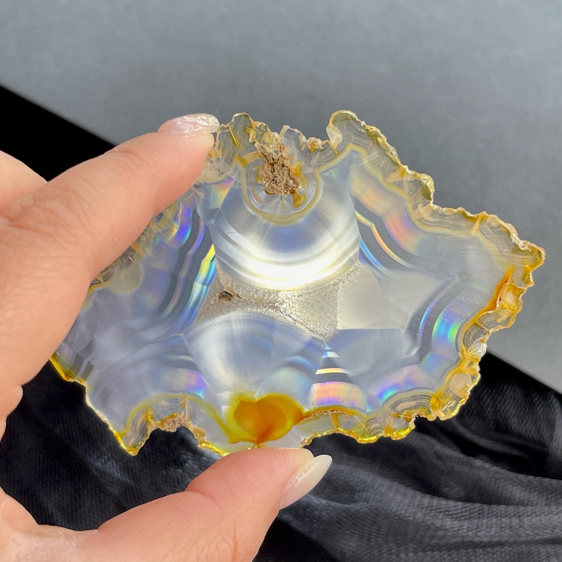 虹彩瑪瑙是一種細帶狀、半透明的石髓 (Chalcedony)，並且可將透射光分解成為光譜顏色。”Iris”意為”彩虹”或”虹彩虹色的”，源自於希臘彩虹女神的名字。  Iris agate is a finely-banded, translucent variety of chalcedony that breaks up transmitted light into spectral colors. The word “Iris” means “rainbow” or “to make iridescent” and is derived from the name of the Greek goddess of the rainbow.     *以上資料轉載自 “GIA Hong Kong - Jul 2021”